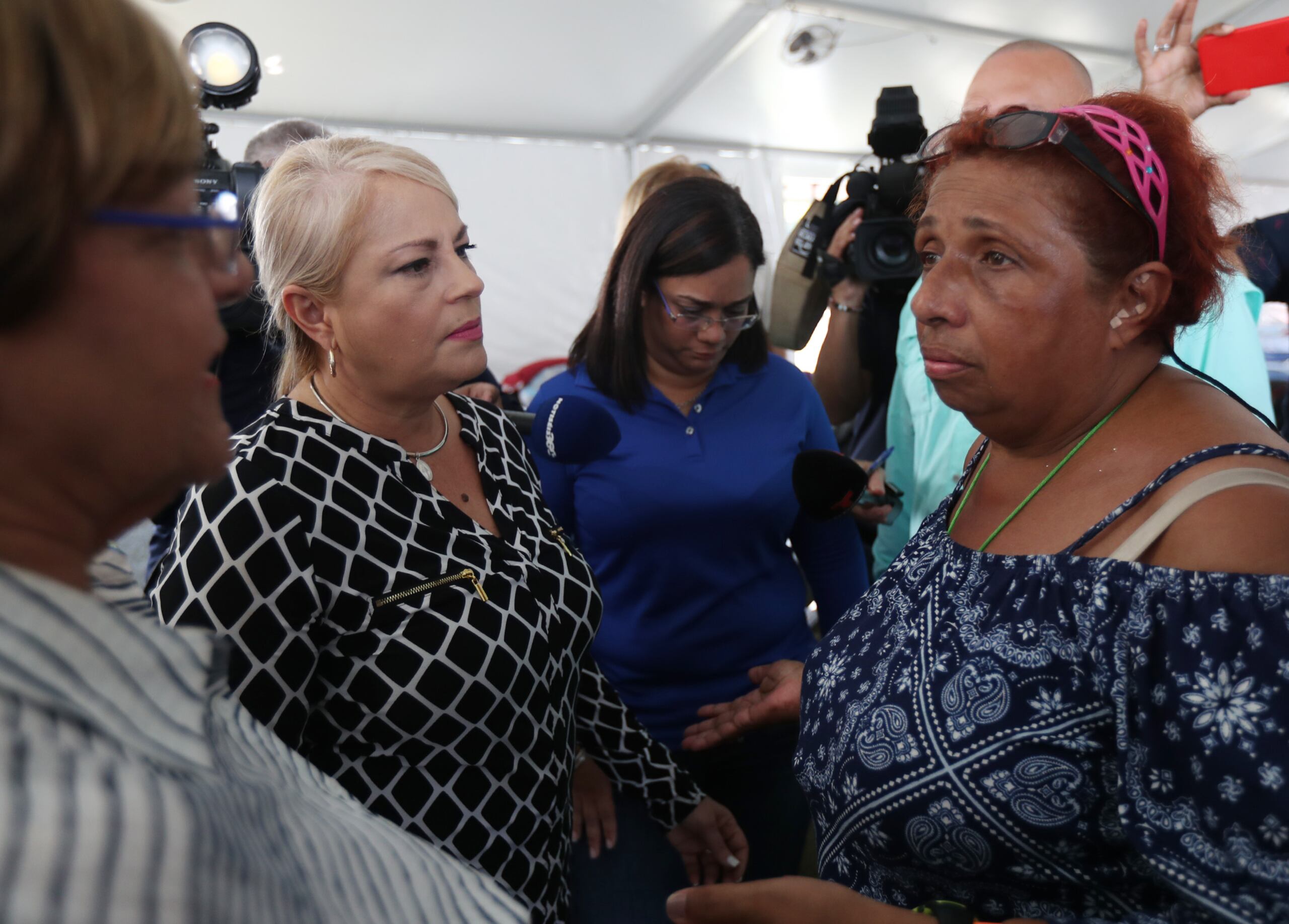 La alcaldesa de Ponce, María Meléndez, y la gobernadora Wanda Vázquez conversan con la refugiada Sandra Márquez, quien se vio afectada por la inundación en el campamento base en la Ciudad Señorial.