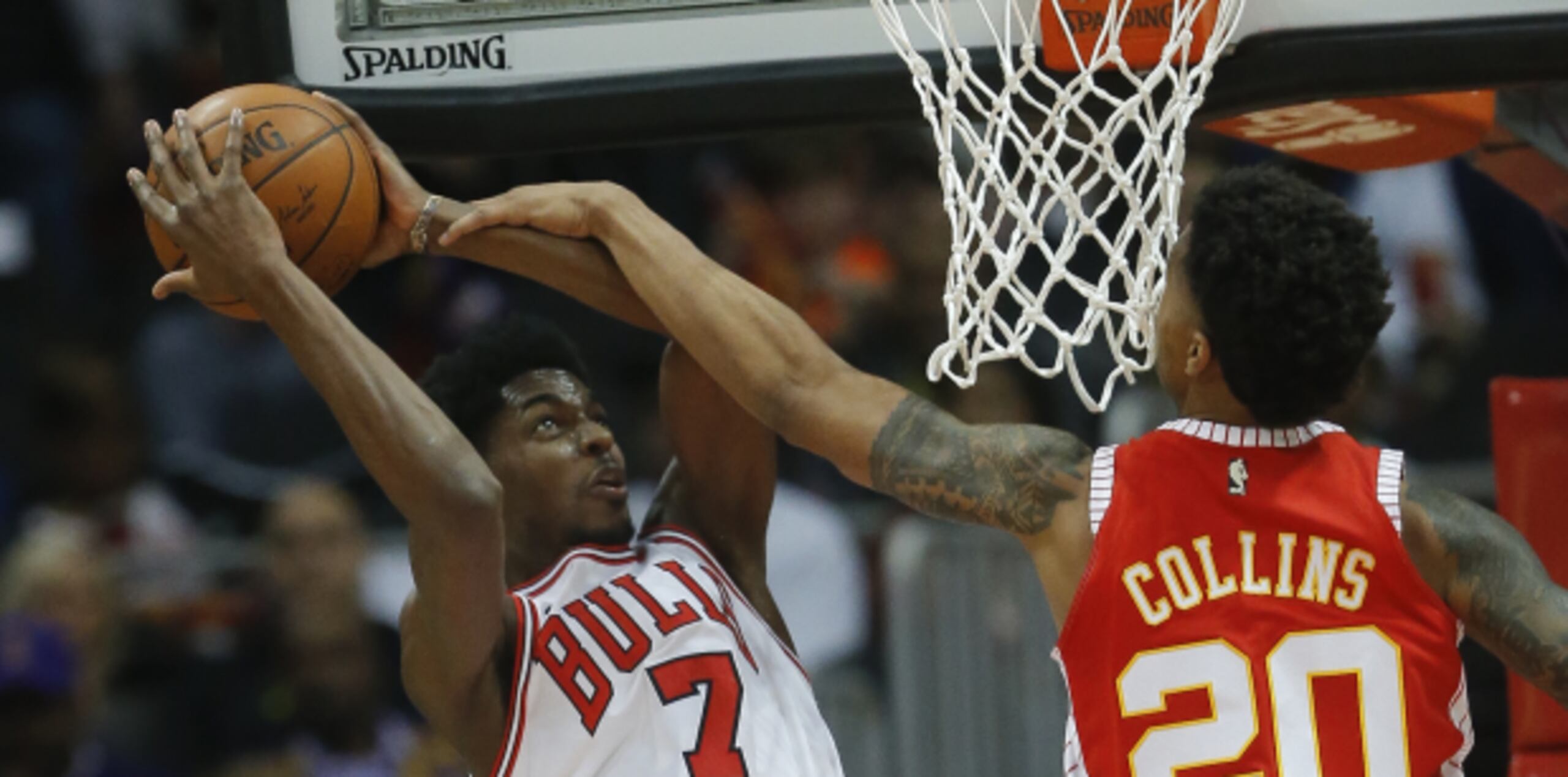 El escolta de los Bulls de Chicago, Justin Holiday, intenta un disparo ante la defensiva de John Collins, de los Hawks de Atlanta, en la primera mitad del juego de hoy. (AP)