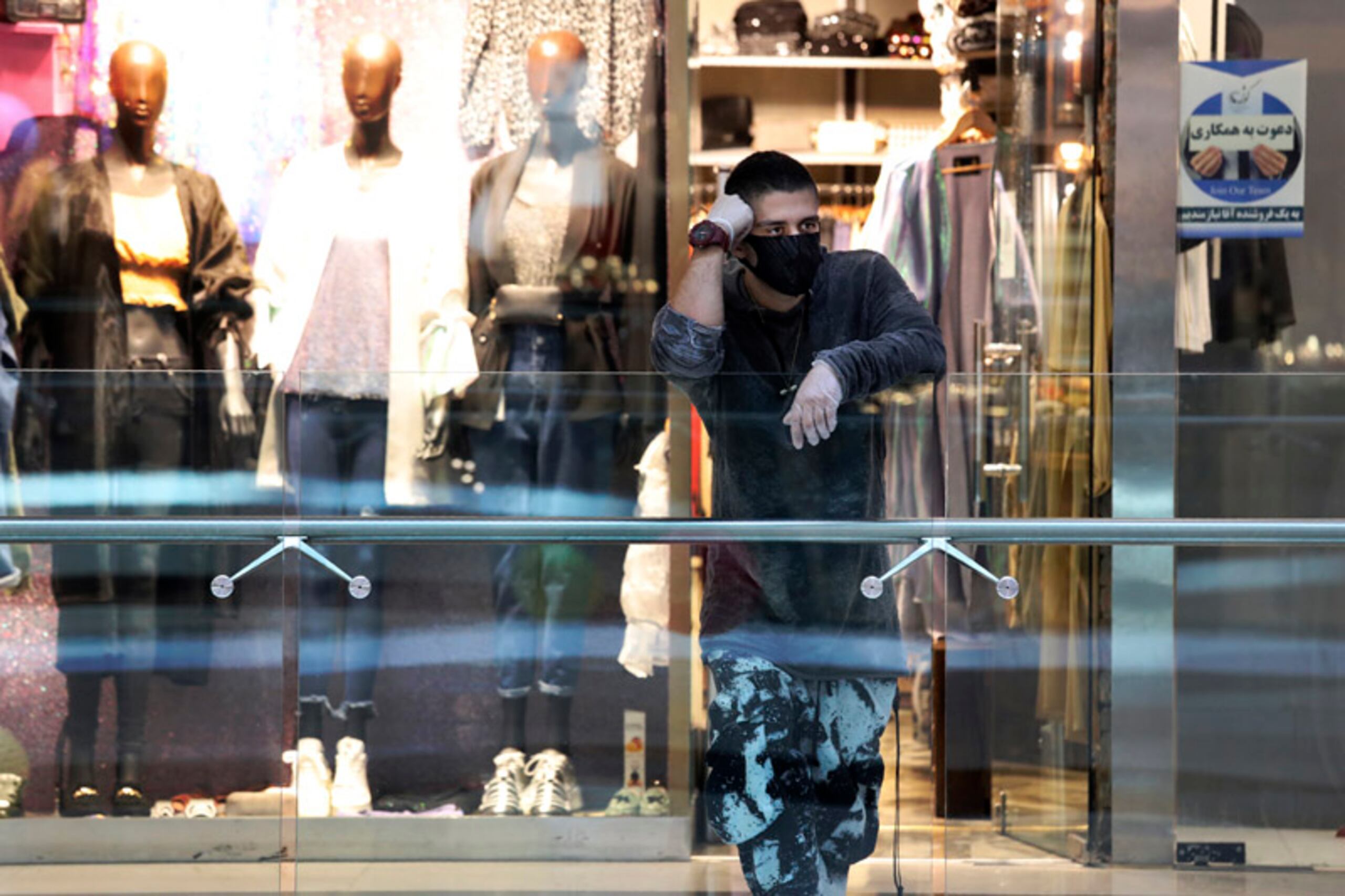 Comerciante usa mascarilla y guantes en el centro comercial Kourosh, en Irán.