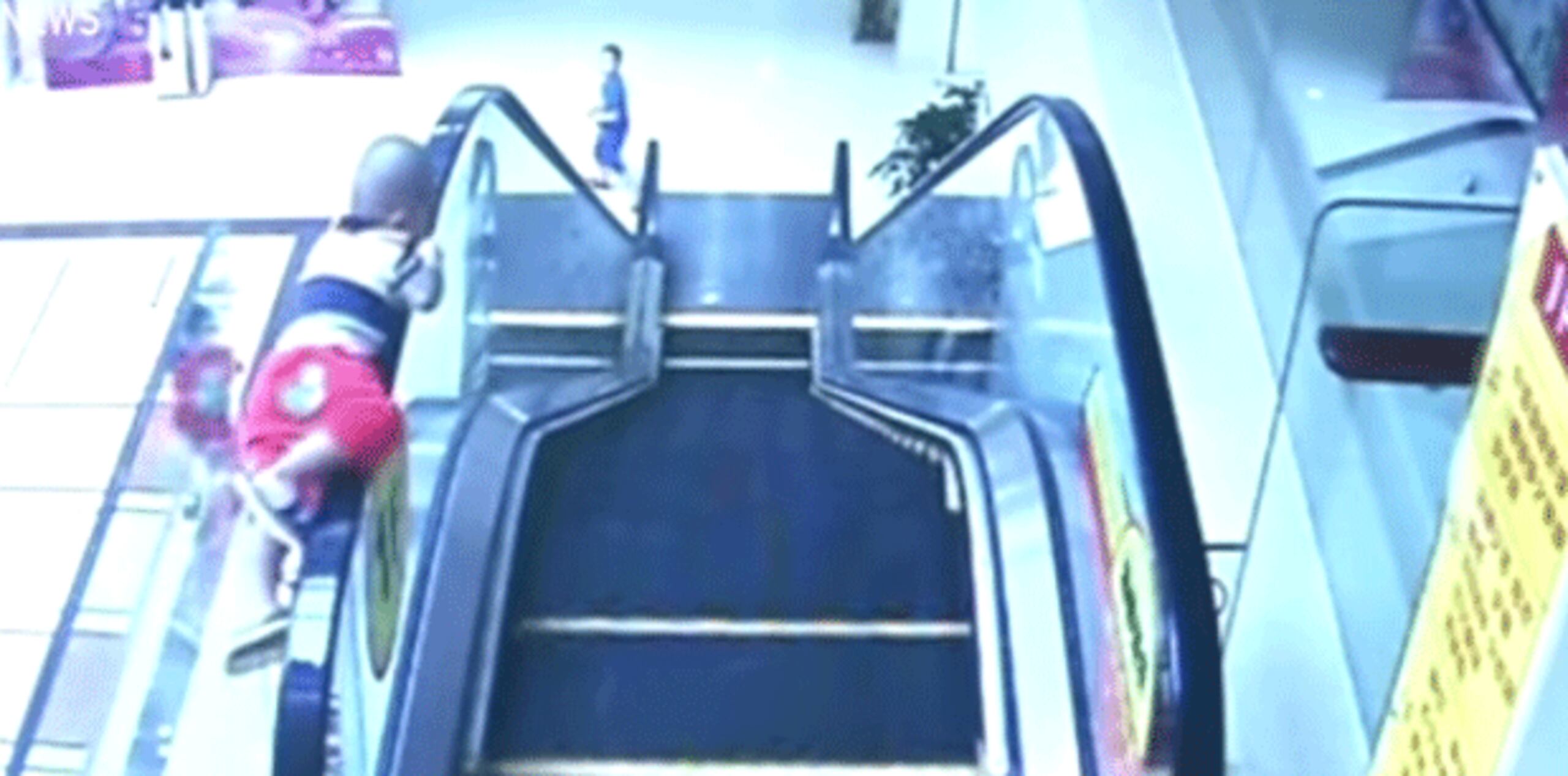 Un vídeo de vigilancia muestra el momento en que el menor sube a la barandilla de la escalera mecánica antes de caer de la misma. (YouTube)