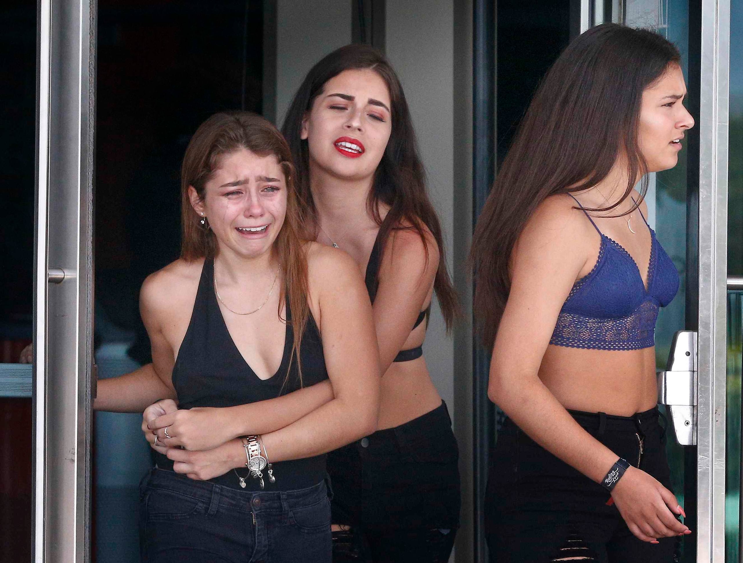 Tres jóvenes lloran tras ver el funeral de XXXTentacion en Sunrise, Florida. (AP / Brynn Anderson)