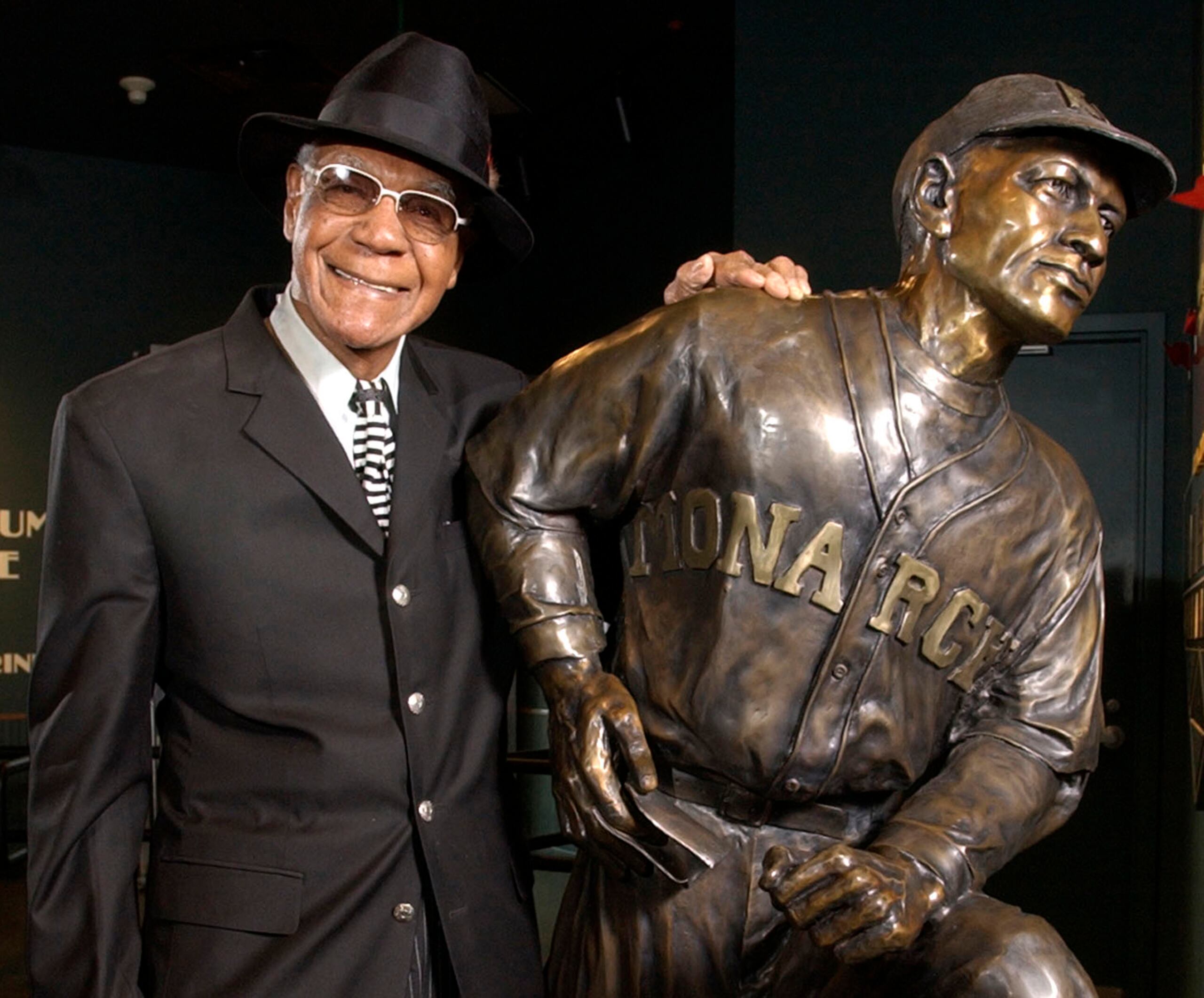 Buck O’Neill, miembro del Salón de la Fama de Cooperstown, posa con su estatua en el Salón de la Fama de las Ligas Negras en Kansas City. Archivo / AP