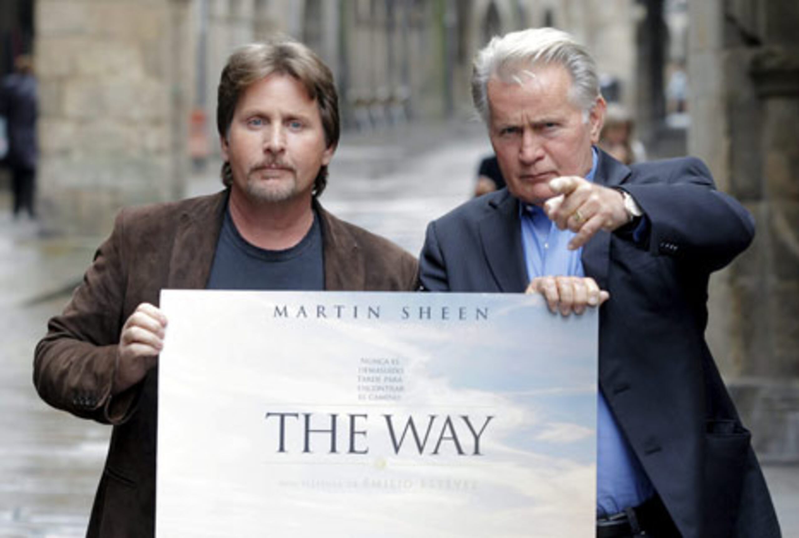 El actor estadounidense de origen gallego y protagonista de "The Way" Martin Sheen, a la derecha, y su hijo y director del fime, Emilio Estévez, posan con el cartel de la película, rodada sobre el Camino de Santiago en Santiago de Compostela, donde se ha presentado a la prensa. (EFE/Lavandeira)