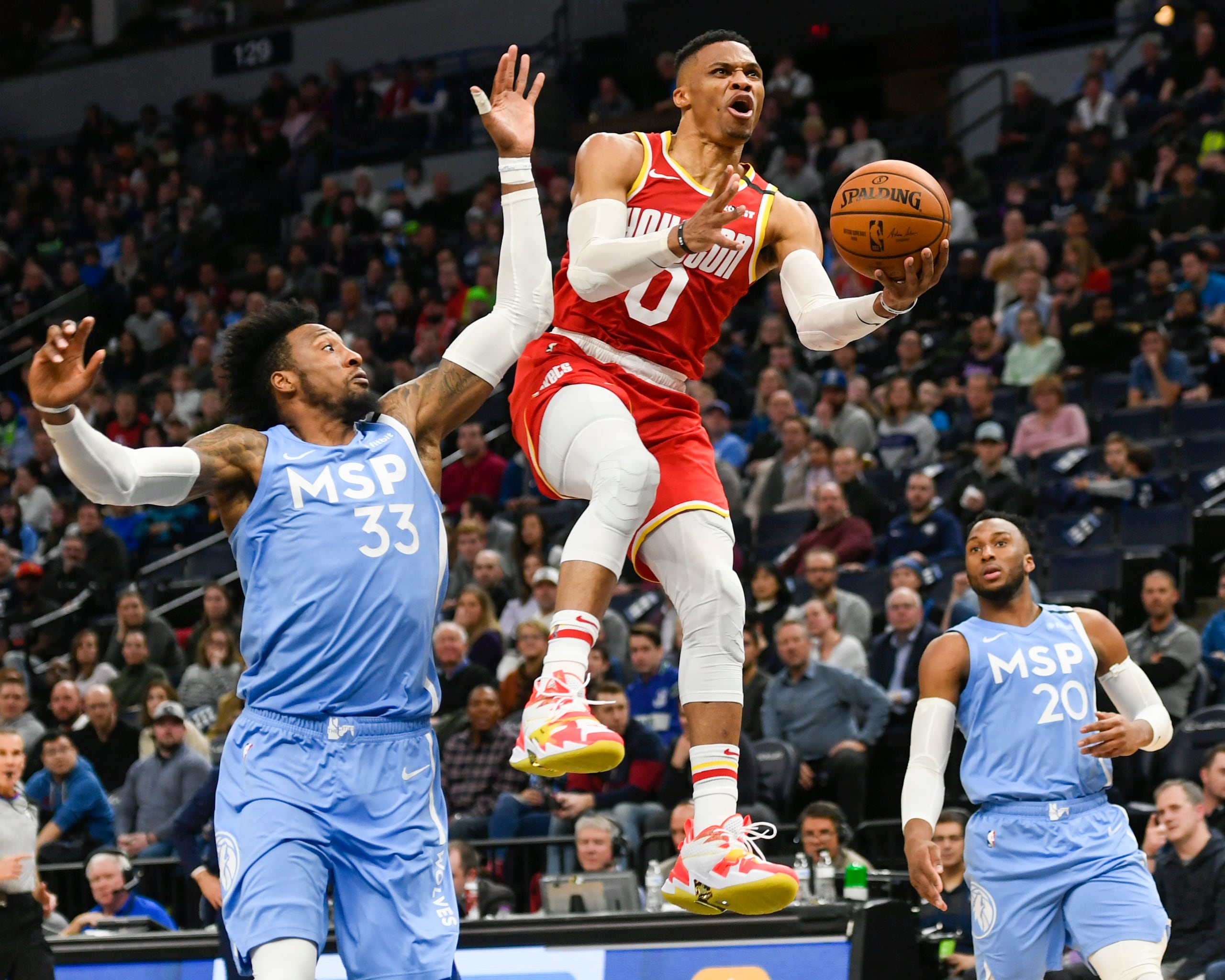 Russell Westbrook (0) deja atrás a los defensores Robert Covington (33) y Josh Okogie (20) para producir dos puntos.