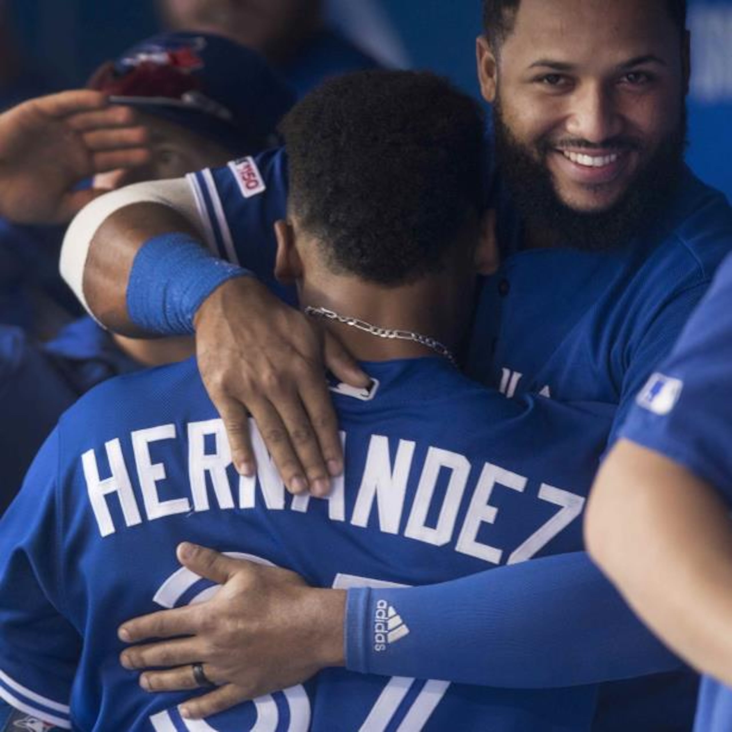 El dominicano Teoscar Hernández, de los Azulejos de Toronto, es abrazado por su compatriota y compañero Richard Ureña, luego de batear un jonrón ante los Rays de Tampa Bay, el sábado.  (AP)