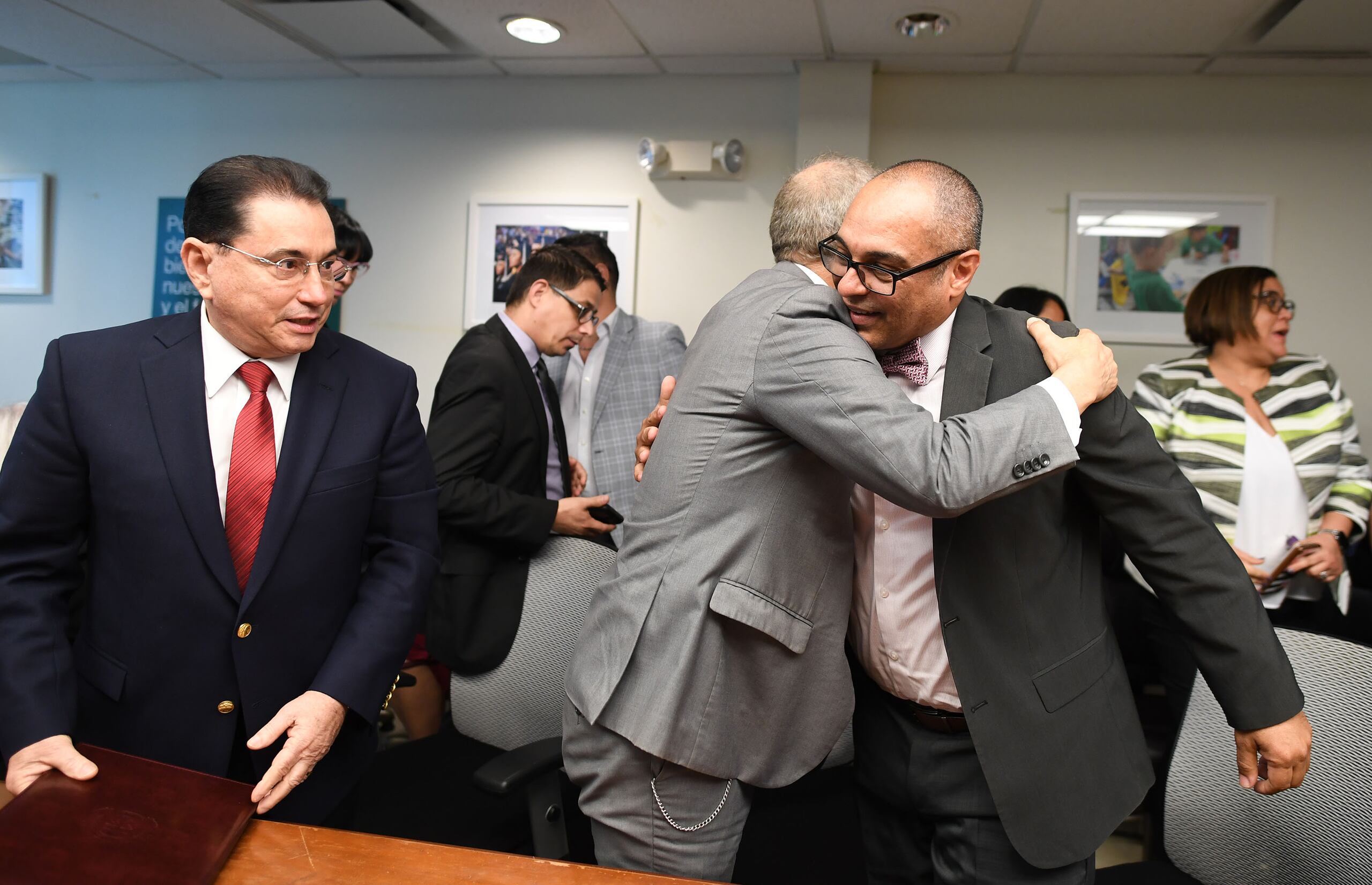 El acuerdo entre Educación -para ofrecer cursos en línea- fue celebrado hoy por  universidades como la de Puerto Rico y la Interamericana. En la foto, el secretario de Educación, Eligio Hernández abraza al presidente de la UPR, Jorge Haddock y al lado, el presidente de la Interamericana, Manuel Fernós.