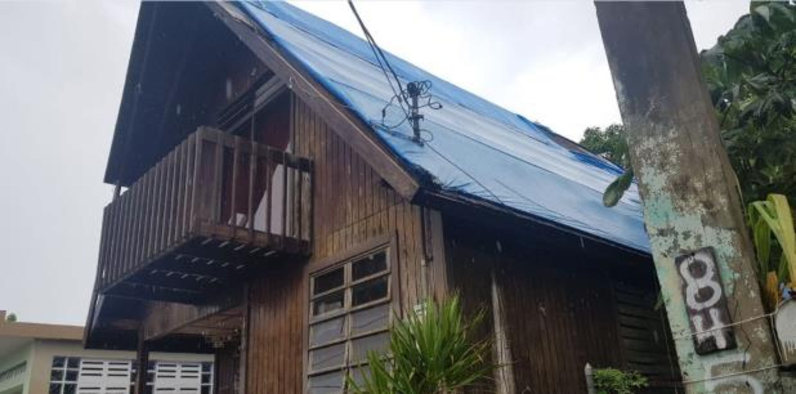 (La casa de dos pisos de madera en la que vive Evelyn Cruz todavía tiene un toldo azul luego del huracán María, por lo que está preocupada por el paso de algún otro fenómeno atmosférico.  Para Primera Hora / Cesiach López Maldonado)