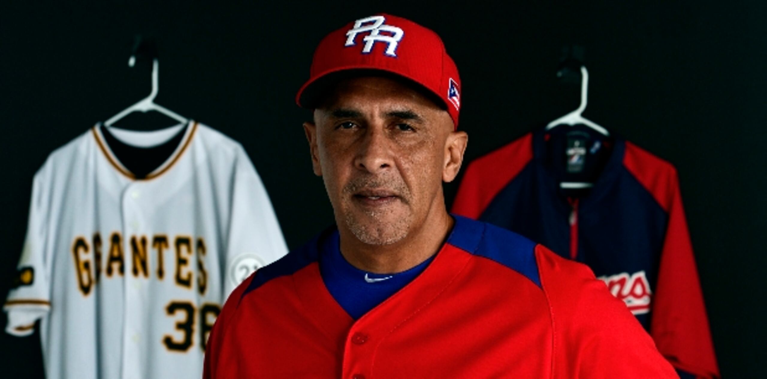 Edwin Rodríguez posa con la camisa que uso en el Clásico Mundial de Béisbol, mientras al fondo se ven las otras insignias que representa en el béisbol. (gerald.lopez@gfrmedia.com)