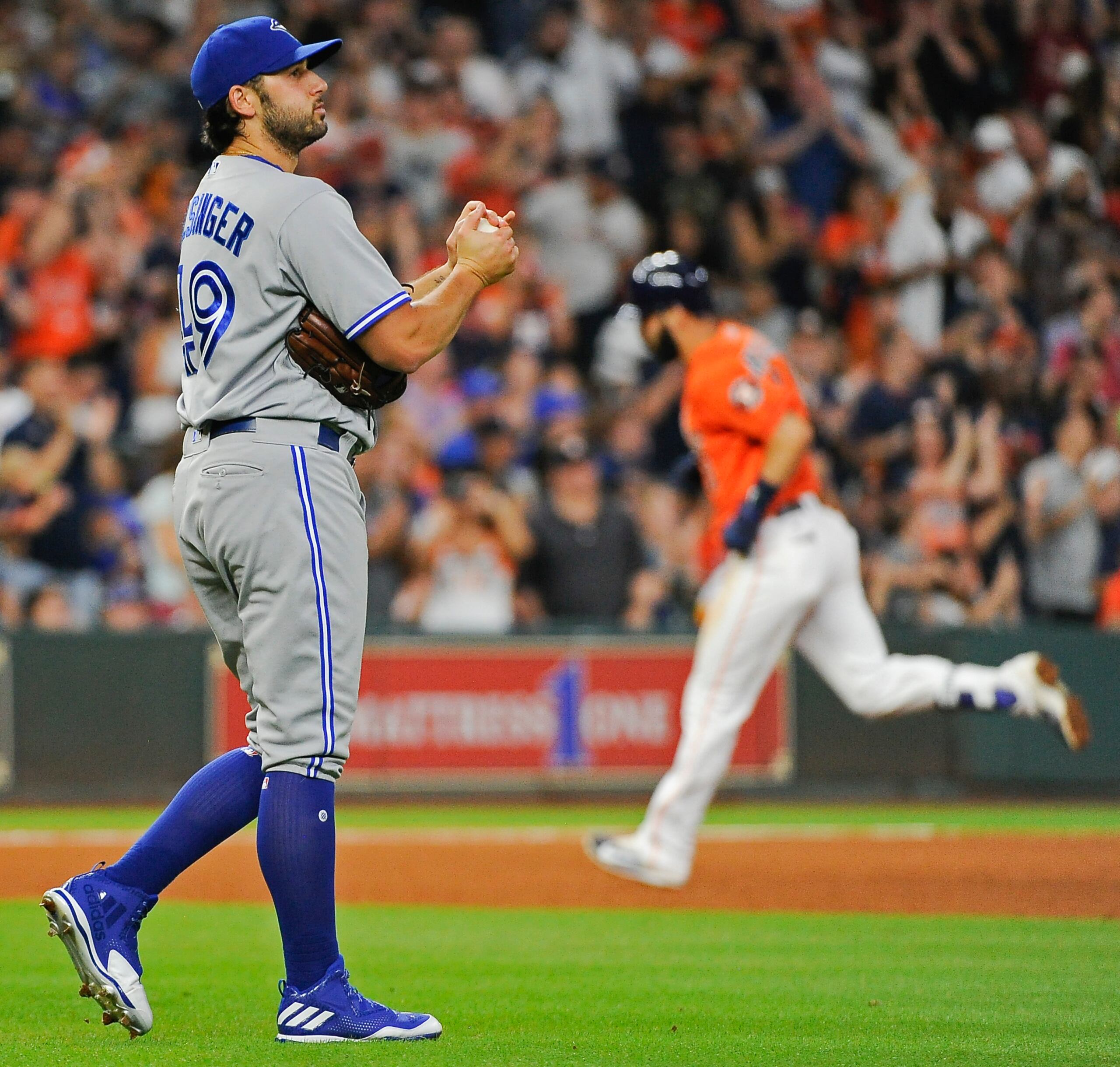 En esta foto del 4 de agosto de 2017, el relevista Mike Bolsinger, de los Azulejos de Toronto, abandona el montículo mientras el venezolano Marwin González, de los Astros de Houston, recorre las bases tras conectar un jonrón de tres carreras. Ese día permitió cuatro carreras y cuatro hits y al día siguiente fue degradado a liga menor.