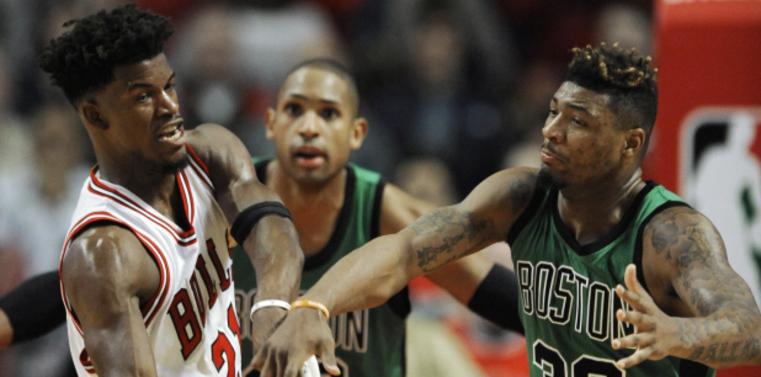 Jimmy Butler pasa el balón ante la presión sometida por Marcus Smart. (Prensa Asociada)