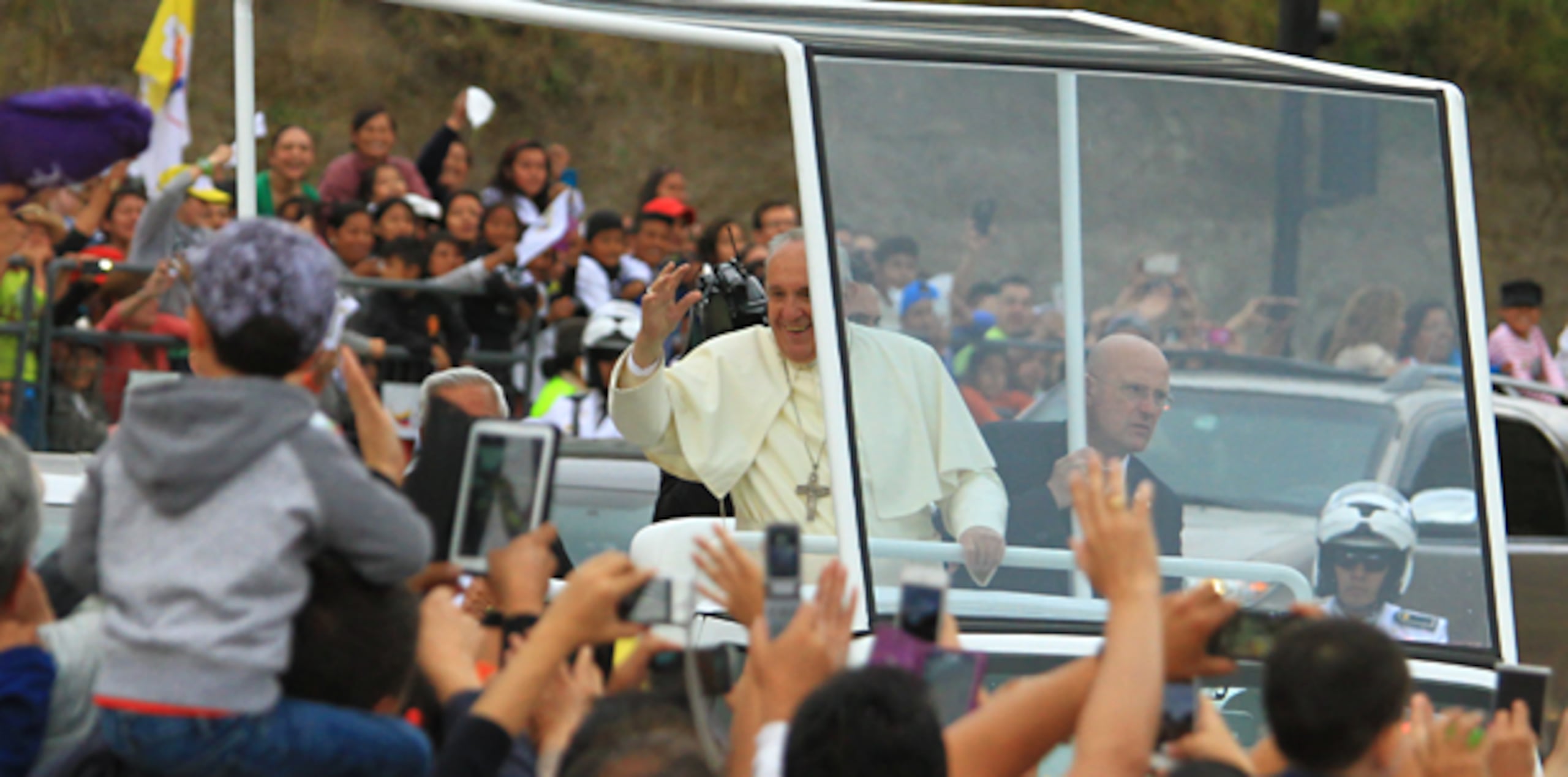 El papa Francisco saluda a los fieles desde su vehículo durante su visita a Quito en la primera parada en su gira latinoamericana, que lo llevará también a Bolivia y Paraguay. (EFE/ Robert Puglla)
