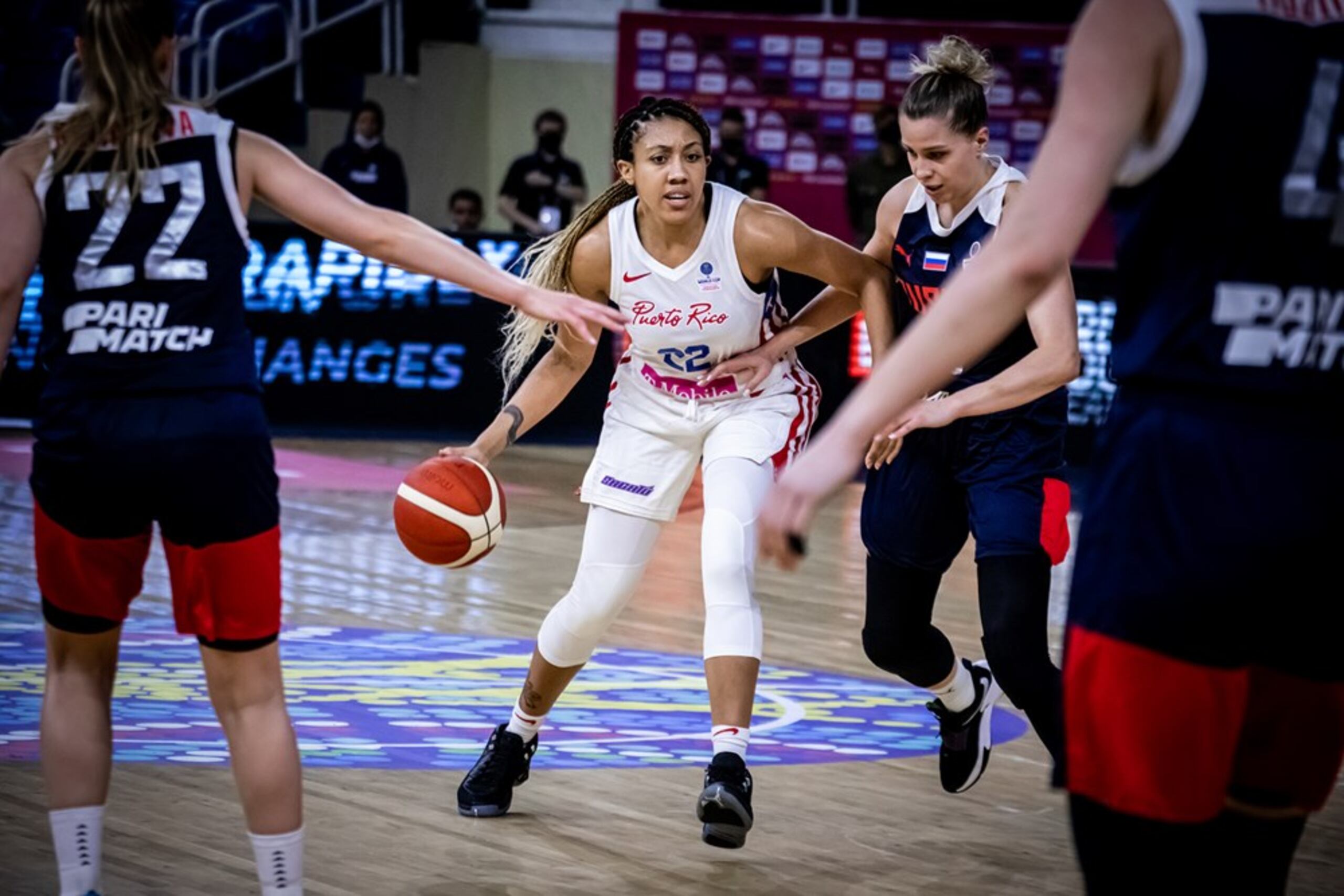 Arella Guirantes, de Puerto Rico, intenta mover el balón ante la defensa de varias jugadoras rusas.