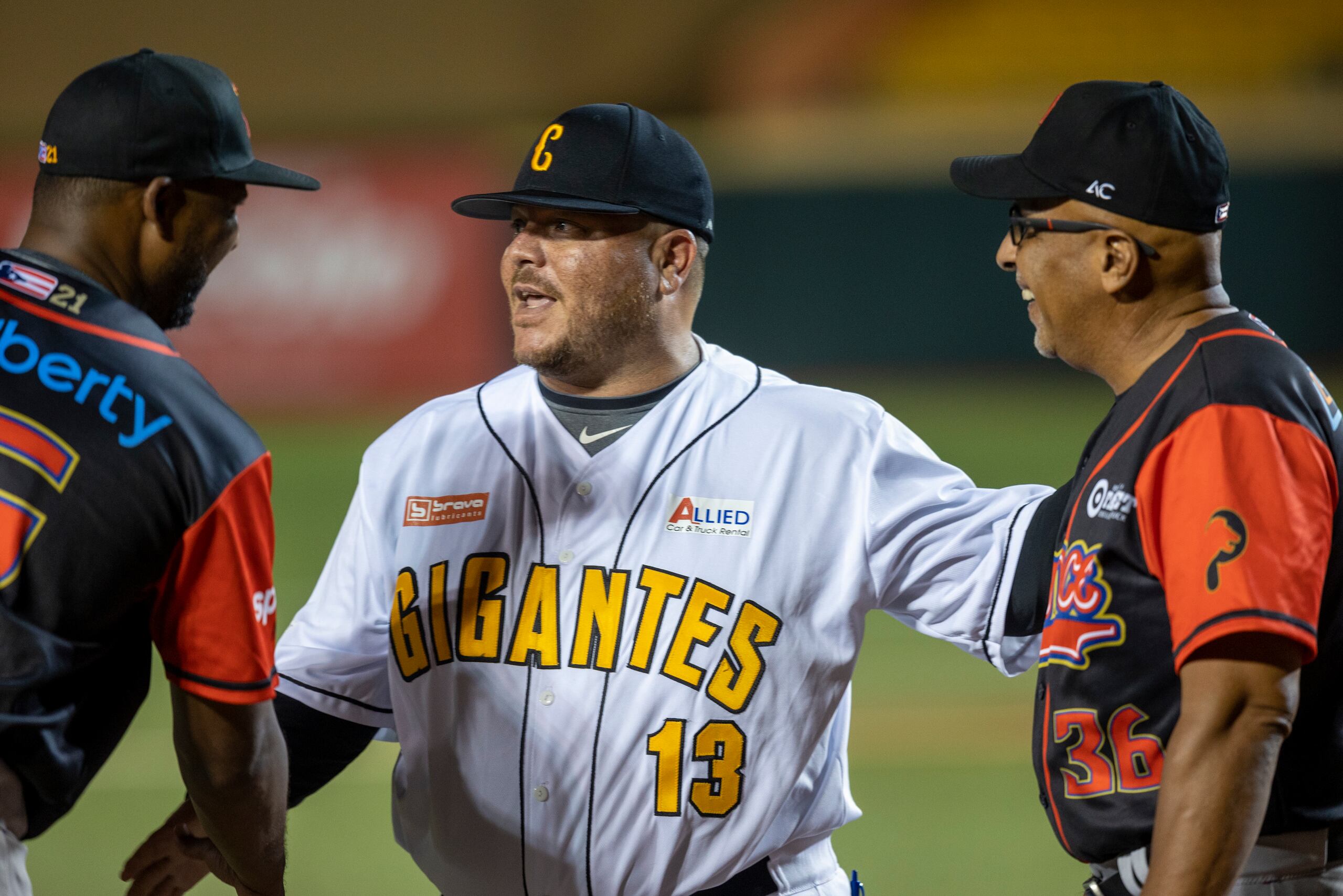 El dirigente de los Gigantes de Carolina, Edwards Guzmán y su contraparte de los Leones de Ponce, Edwin Rodríguez, a la derecha, bromean antes de un partido en la actual temporada de la liga invernal boricua.