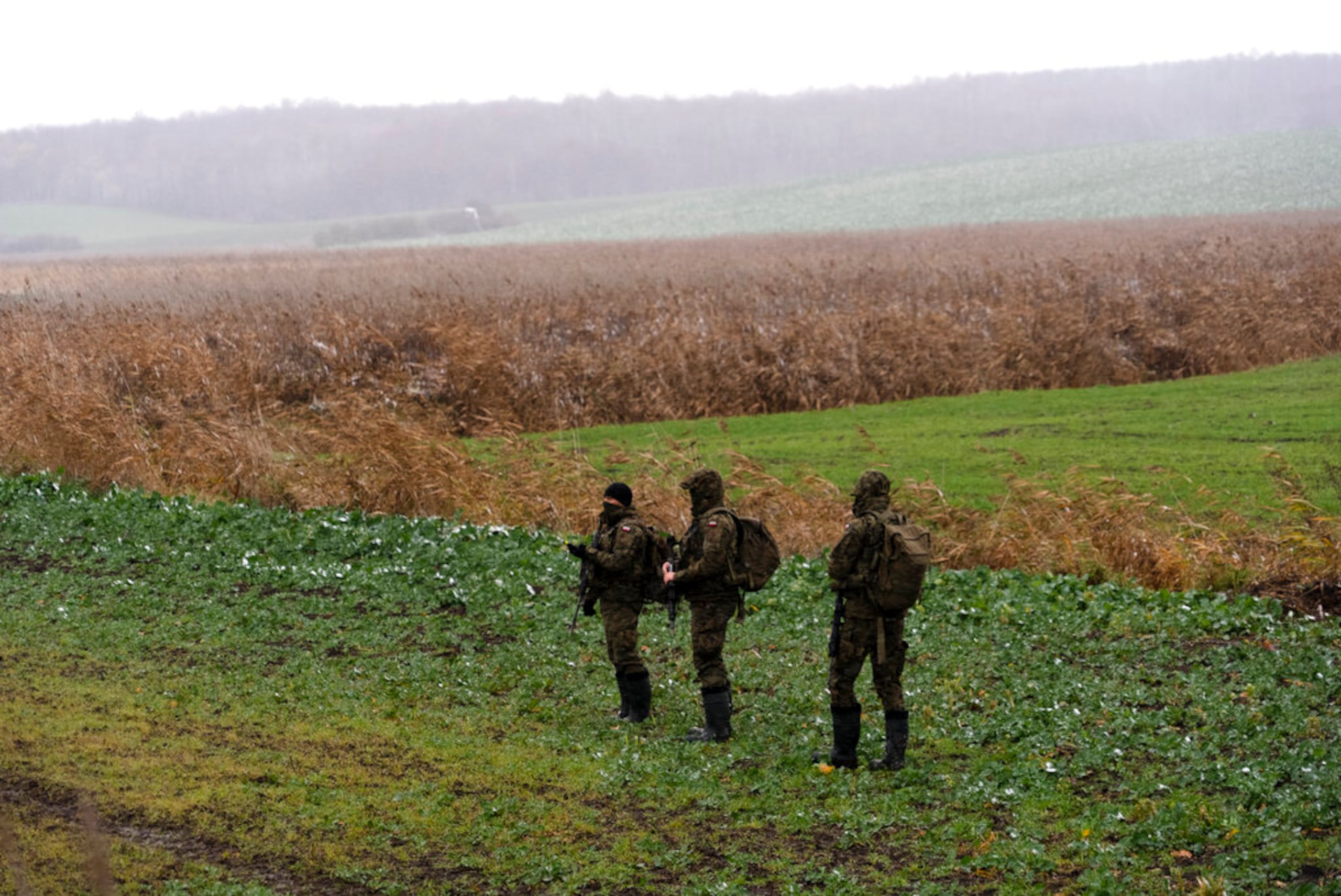 Soldados polacos buscan restos de misiles en el campo, cerca del lugar donde cayó un misil, en una tierra de cultivo en la aldea polaca de Przewodów, cerca de la frontera con Ucrania, el 17 de noviembre de 2022.