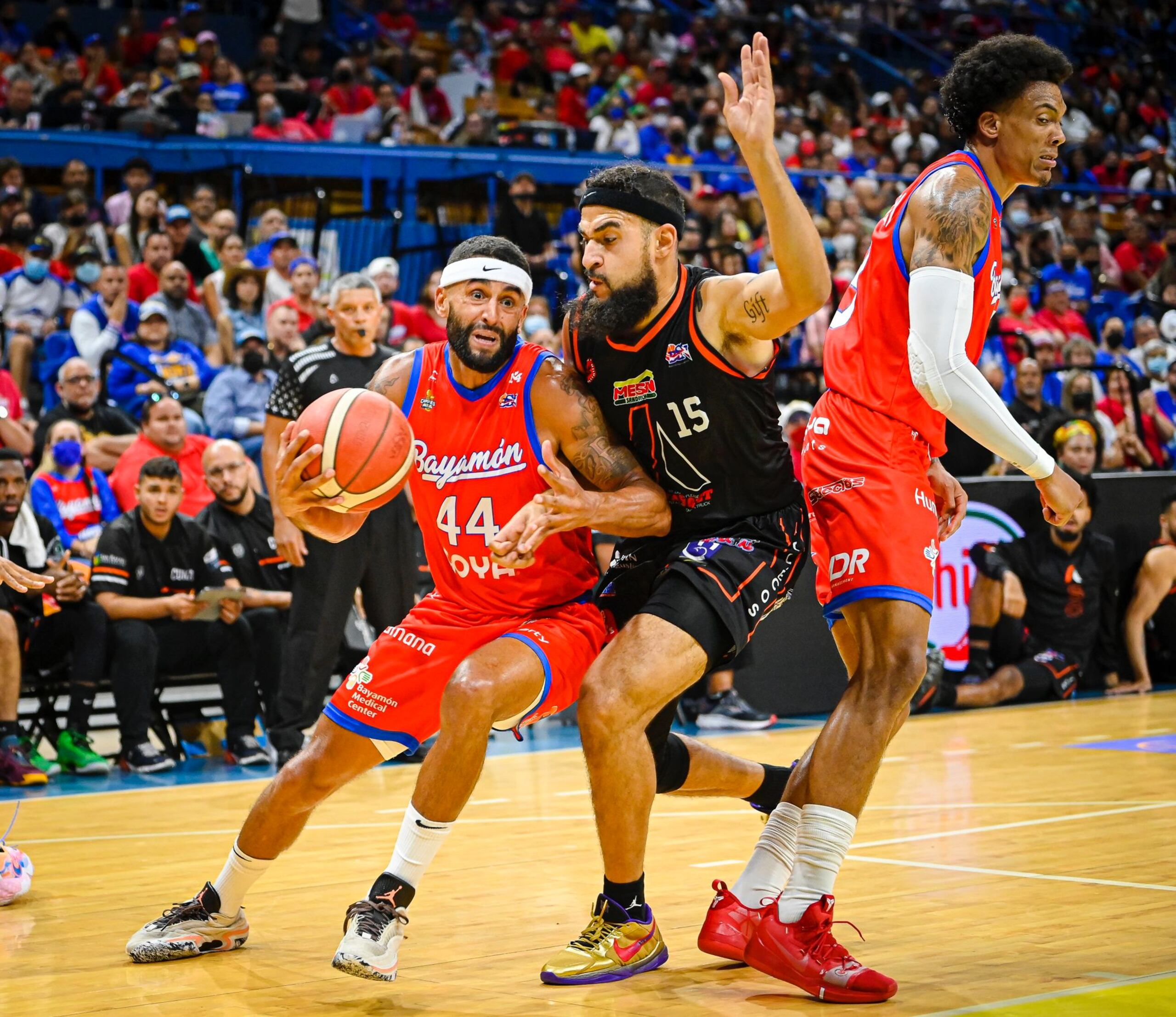 Javier Mojica (44), de los Vaqueros, trata de sacarse de encima la defensa de Onzie Branch, de los Atléticos, con una cortina que le hace el importado Jacob Wiley. Mojica fue el mejor del partido el viernes al finalizar con 23 puntos, entre los que incluyó cinco canastos de tres.