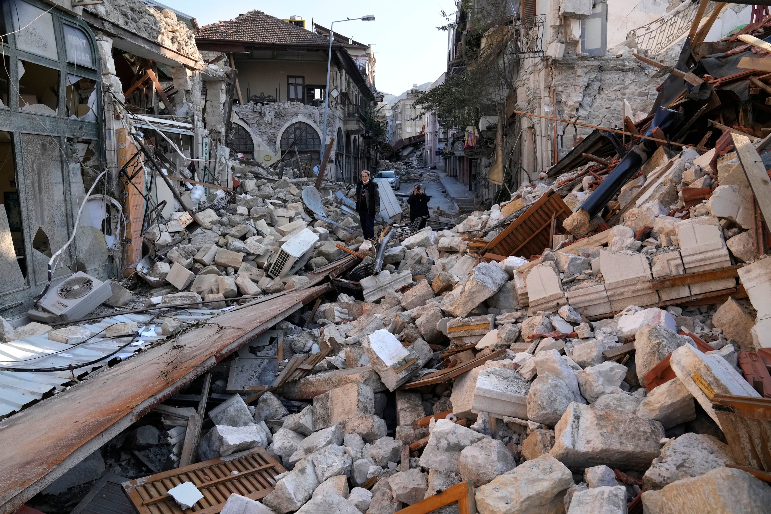 Una mujer turca sobre los escombros de las casas patrimoniales que se destruyeron durante el devastador terremoto, en la antigua ciudad de Antakya, en el sur de Turquía, el lunes 13 de febrero de 2023.