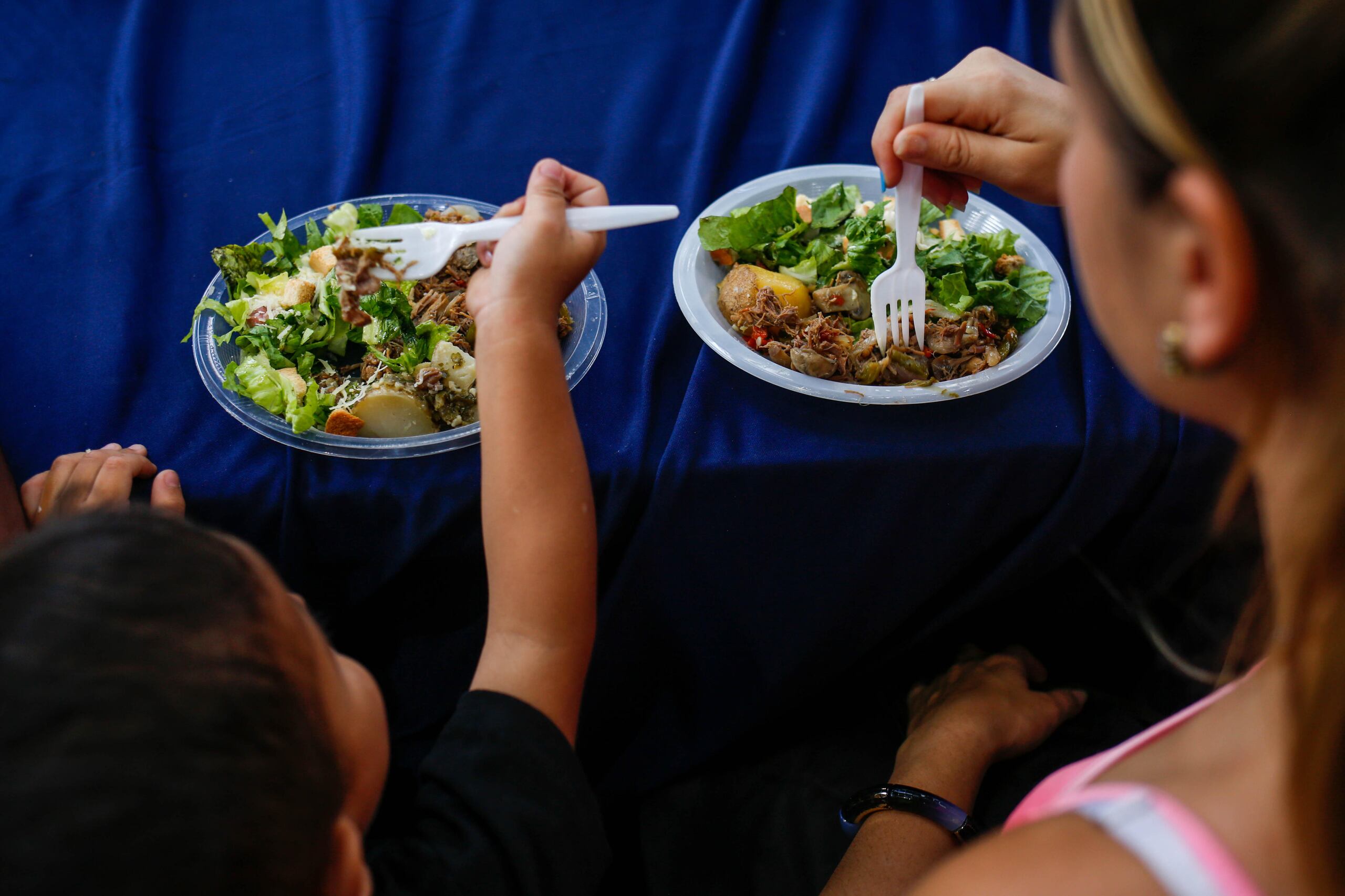 Una mujer y su hijo consumen un almuerzo, en una fotografía de archivo. EFE/Cristian Hernández
