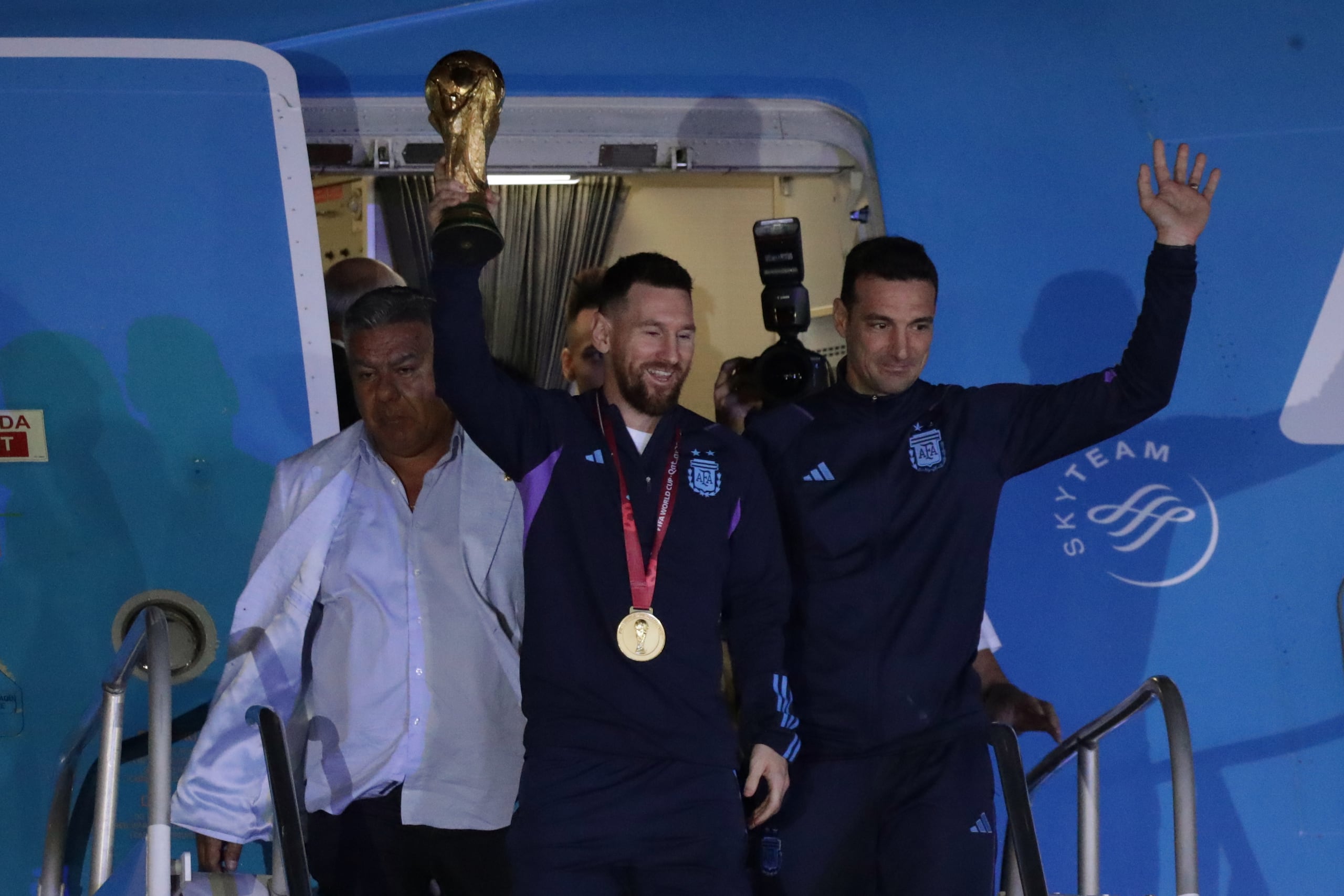 Lionel Messi de la selección argentina de fútbol saluda con el trofeo del Mundial de Fútbol Qatar 2022 junto al seleccionador Lionel Scaloni (d) a su llegada hoy, al Aeropuerto Internacional de Ezeiza a unos 22km de Buenos Aires (Argentina). EFE/ Raúl Martínez
