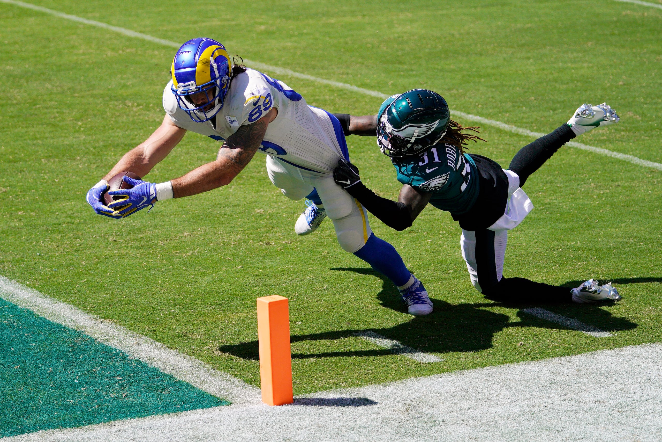 Tyler Higbee, izquierda, anota un touchdown ante los esfuerzos de Nickell Robey-Coleman, de los Eagles de Filadelfia.