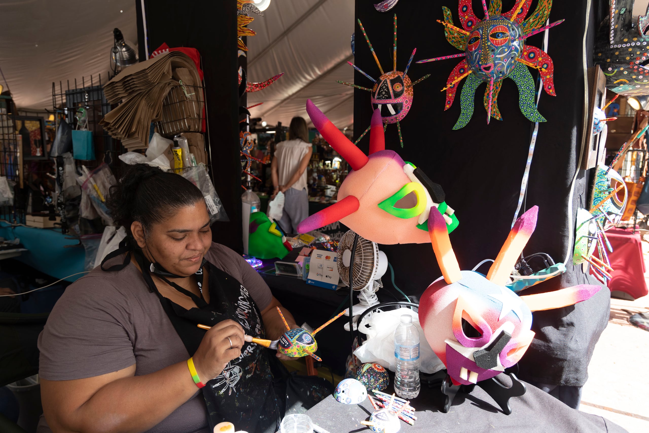 Minerva Hernández, dando los detalles finales a una máscara de vejigante, es una de cientos de artesanos que exhiben este año en las Fiestas de la Calle San Sebastián.