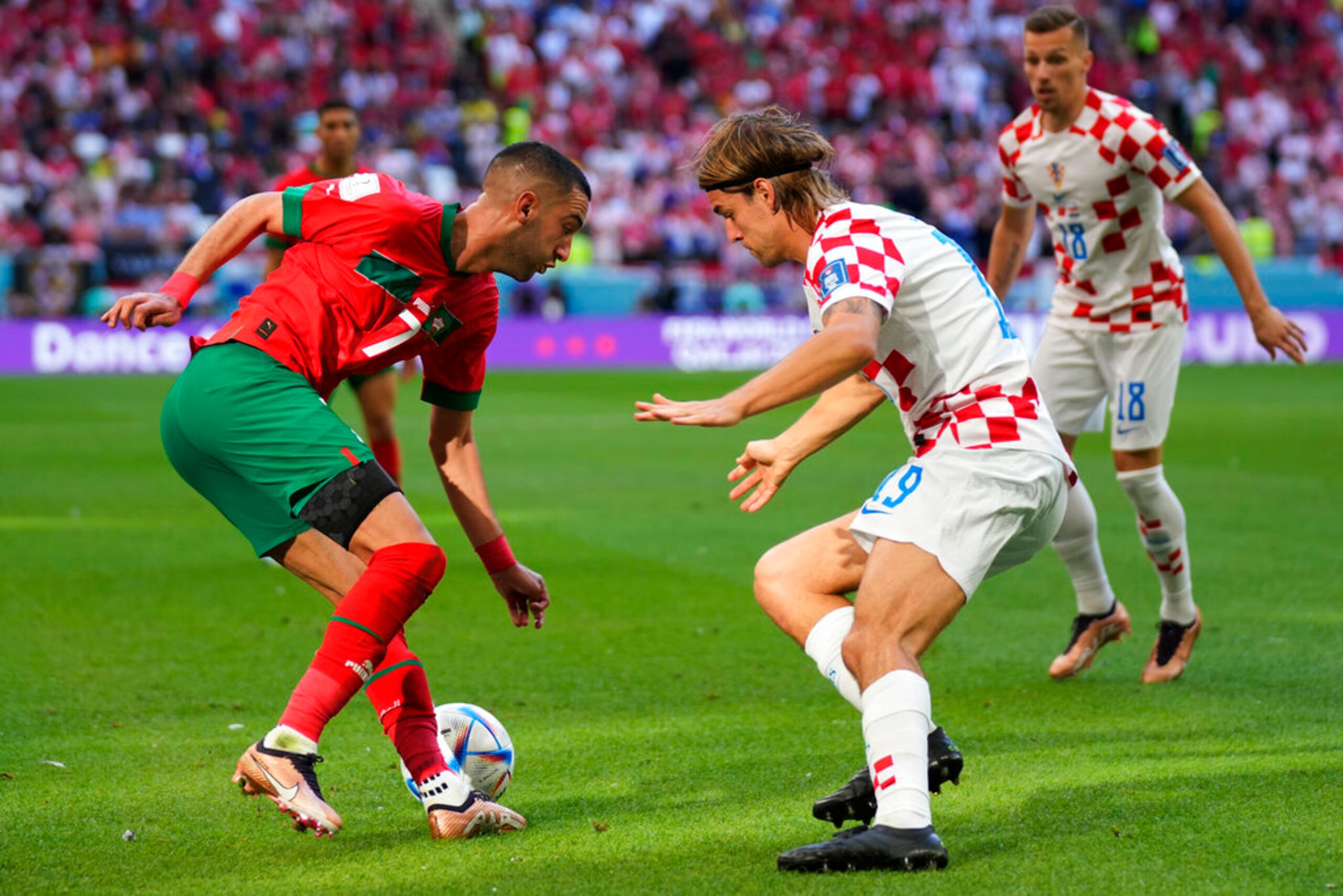 El croata Borna Sosa (centro) y el marroquí Hakim Ziyech disputan el balón durante el partido por el Grupo F del Mundial en el estadio Al Bayt en Jor, Qatar.