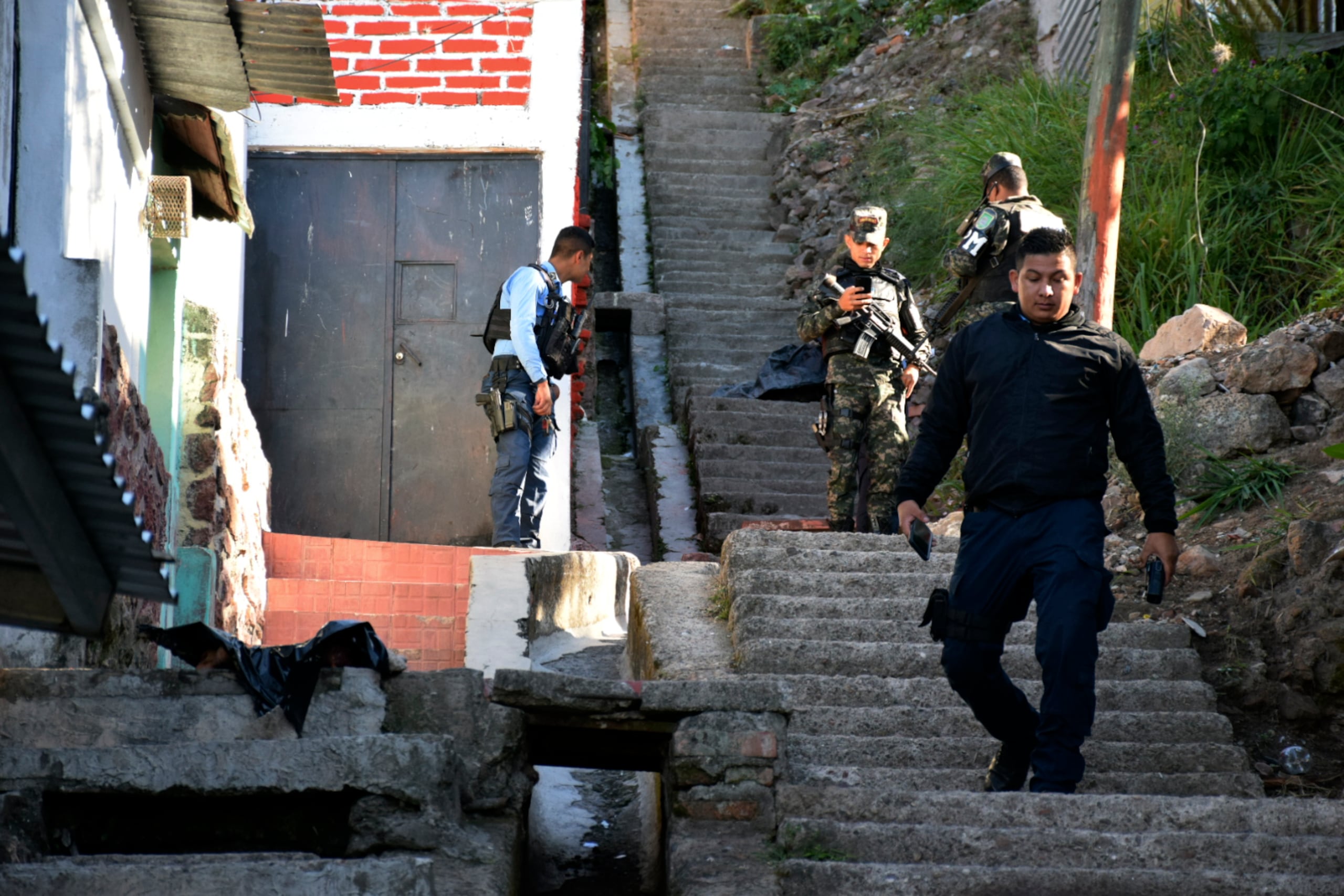 Policías acordonan la zona donde fue encontrado un cuerpo mutilado, el 22 de marzo de 2023, en Tegucigalpa, en Honduras. (EFE/ STR)