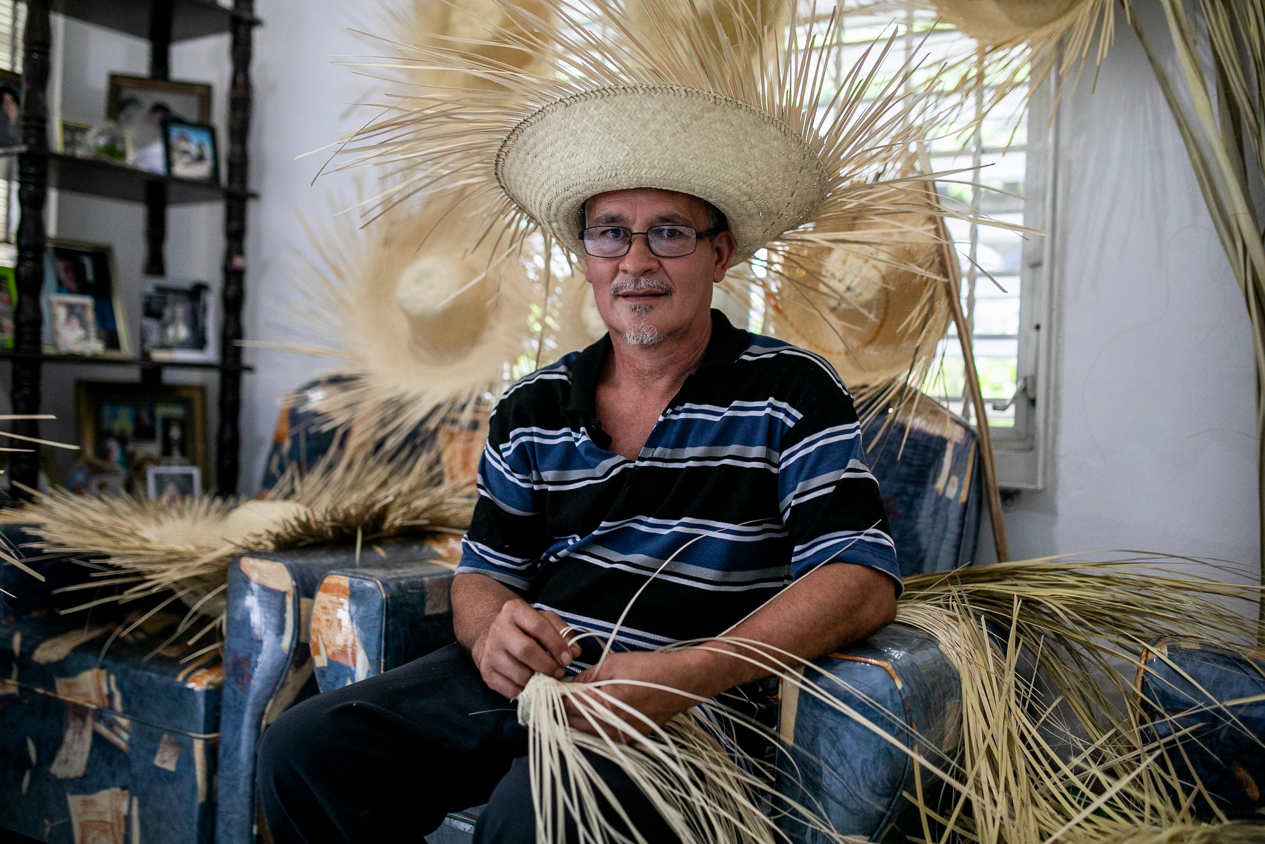 El tiempo que le dedica a sus artesanías es al terminar su jornada de trabajo regular, cuando se sienta a entrelazar las hojas de palma frente al televisor en su casa, en el barrio Cerro Gordo.