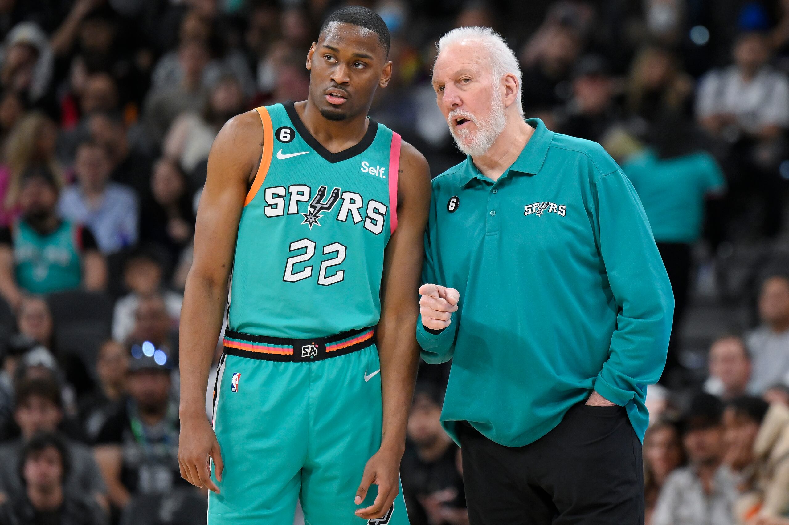 El entrenador de los Spurs, Gregg Popovich, a la derecha, ofrece instrucciones a Malaki Branham durante un reciente partido del equipo ante los Mavs de Dallas.