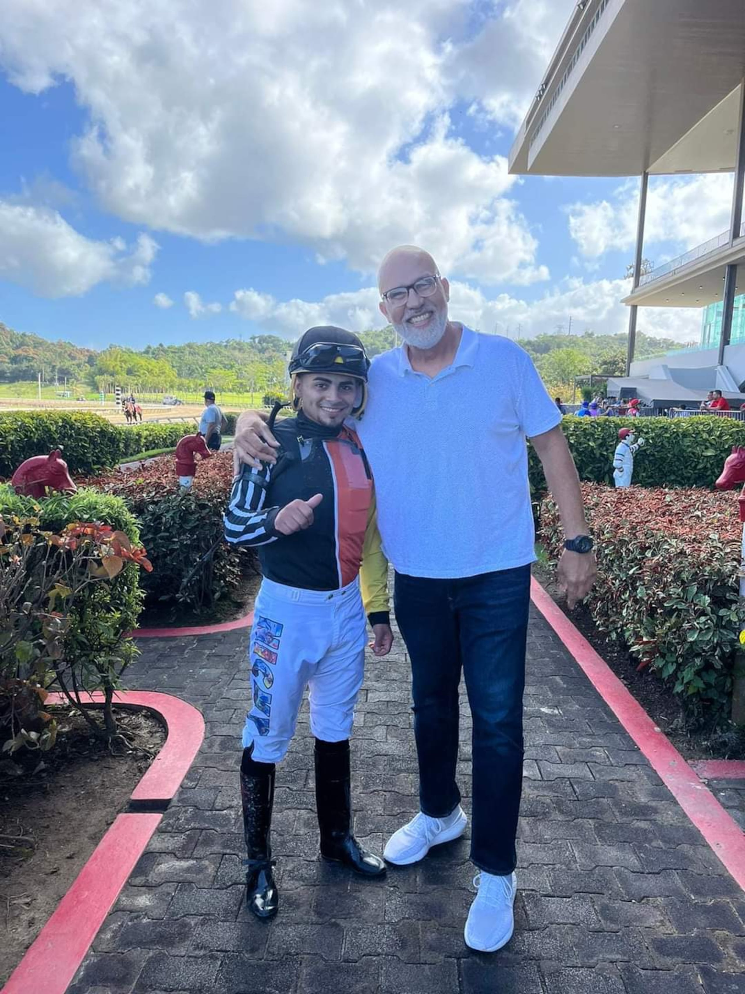 Carlos Tarrats posa junto a su jinete ganador Nicky Figueroa, que viste los colores del estable del exárbitro, como se puede notar en la manga derecha de la blusa del jockey.