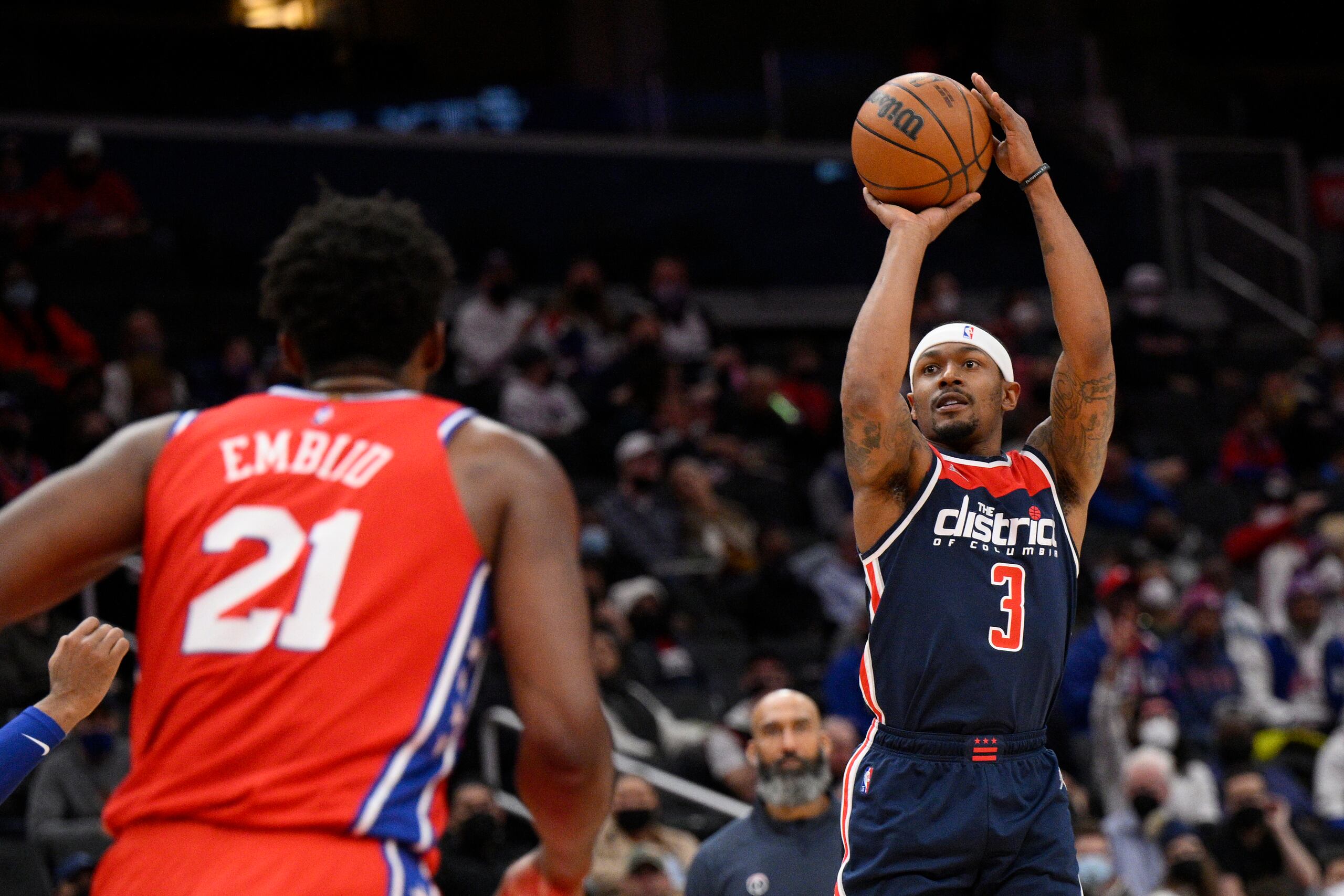 El base de los Wizards de Washington Bradley Beal lanza ante el pívot de los 76ers de Filadelfia Joel Embiid durante la primera mitad del partido de la NBA, el lunes 17 de enero de 2022, en Washington.