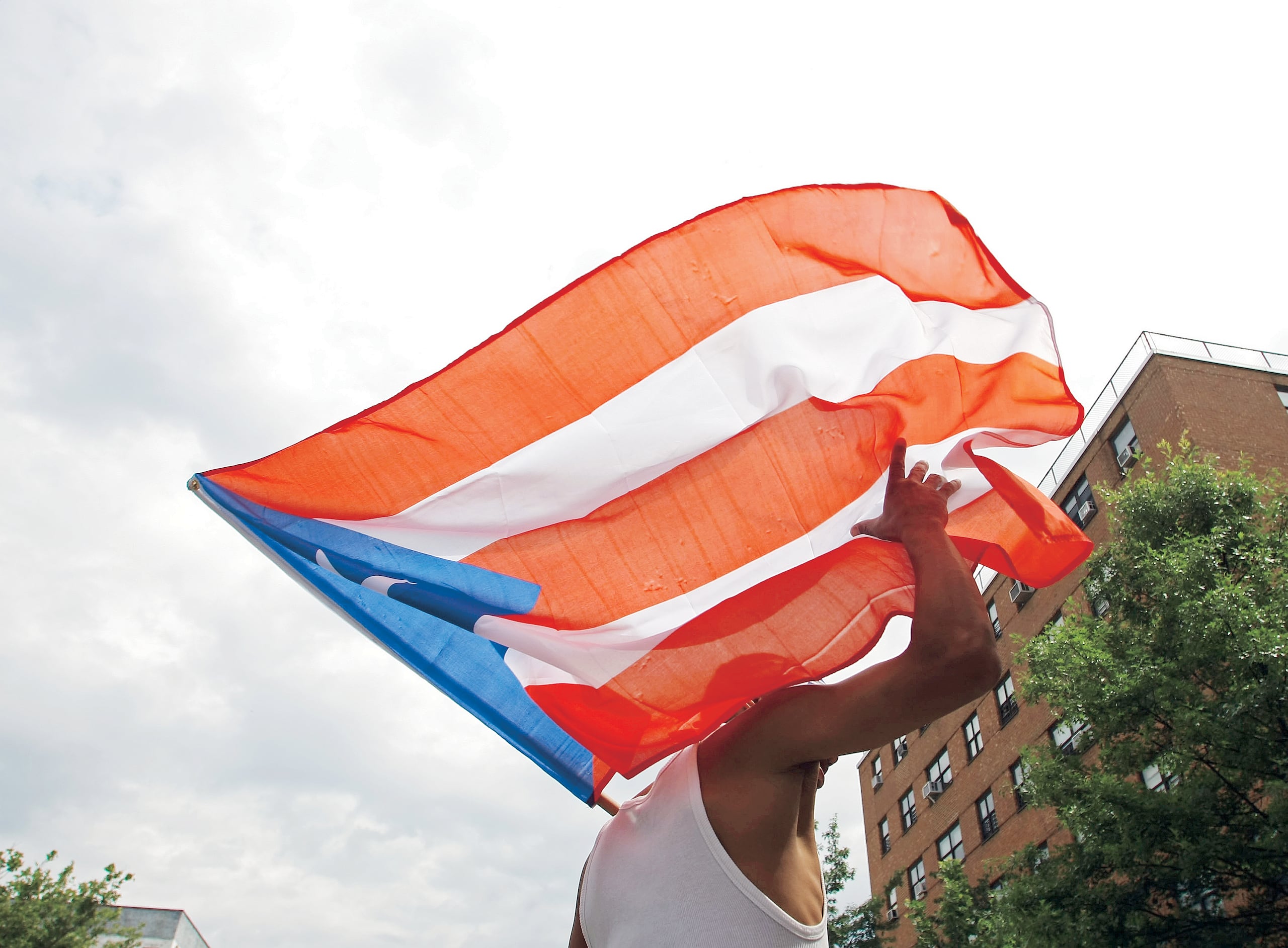 Un hombre ondea una bandera de Puerto Rico.