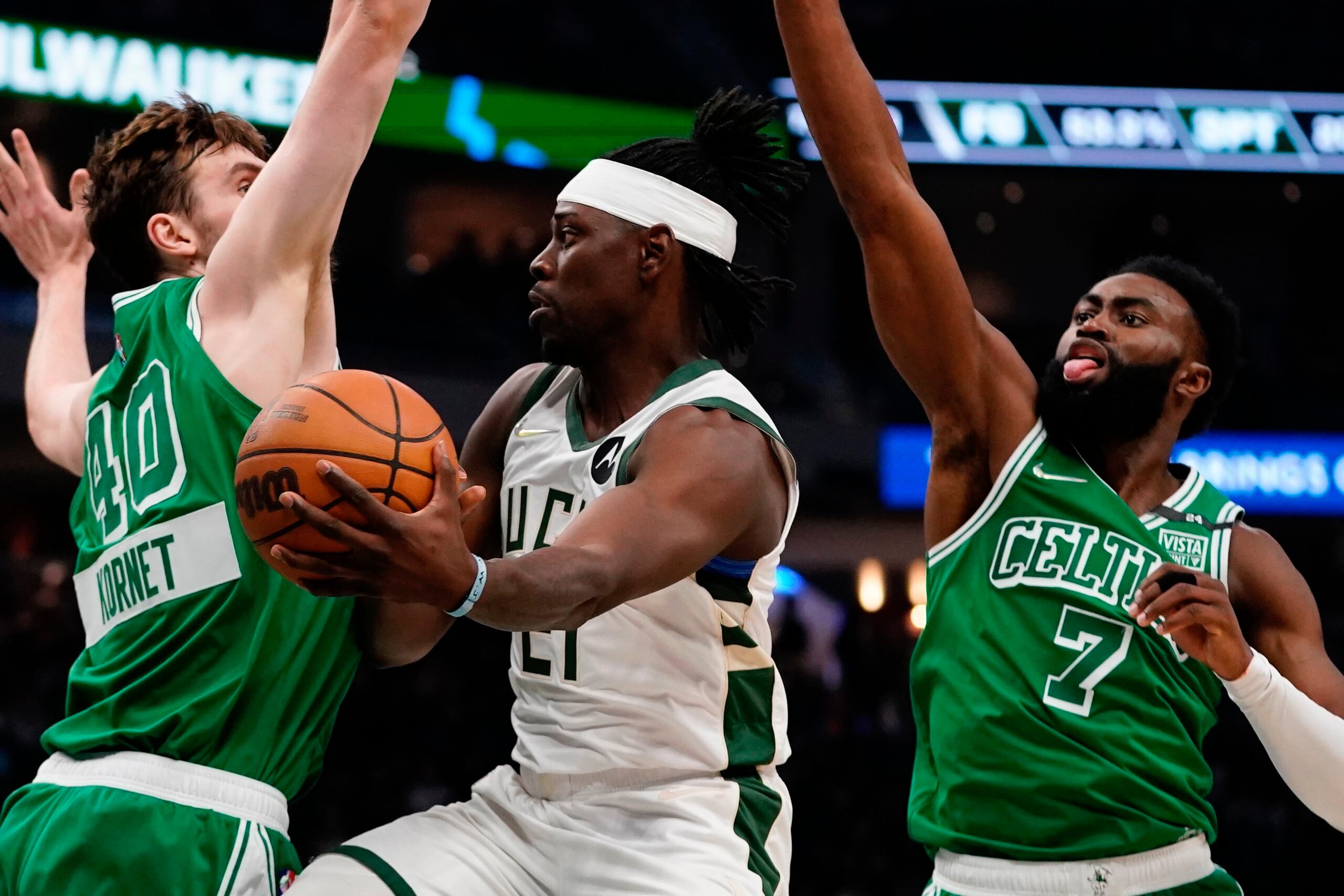 Jrue Holiday, de los Bucks, se cuela entre la defensa de Luke Kornet, a la izquierda, y Jaylen Brown, en medio de una jugada de la primera mitad del encuentro del jueves.