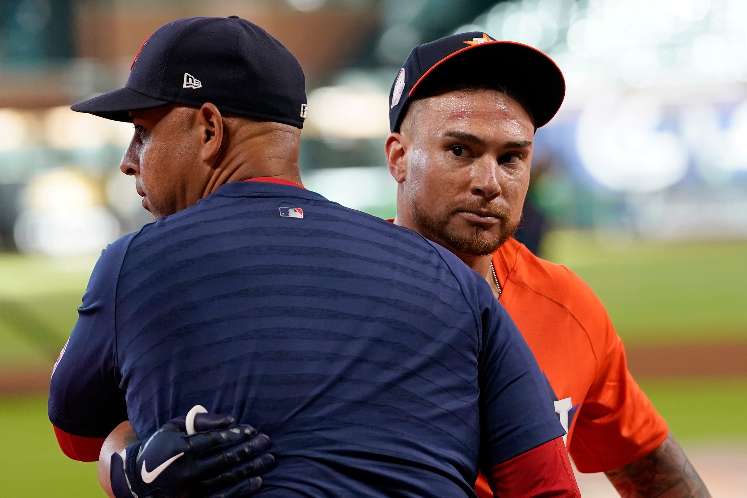 El dirigente de los Red Sox de Boston, Alex Cora, abraza a Christian Vázquez, ya con uniforme de los Astros de Houston, justo el primer día que fue traspasado de equipo previo a un juego entre dichas novenas.