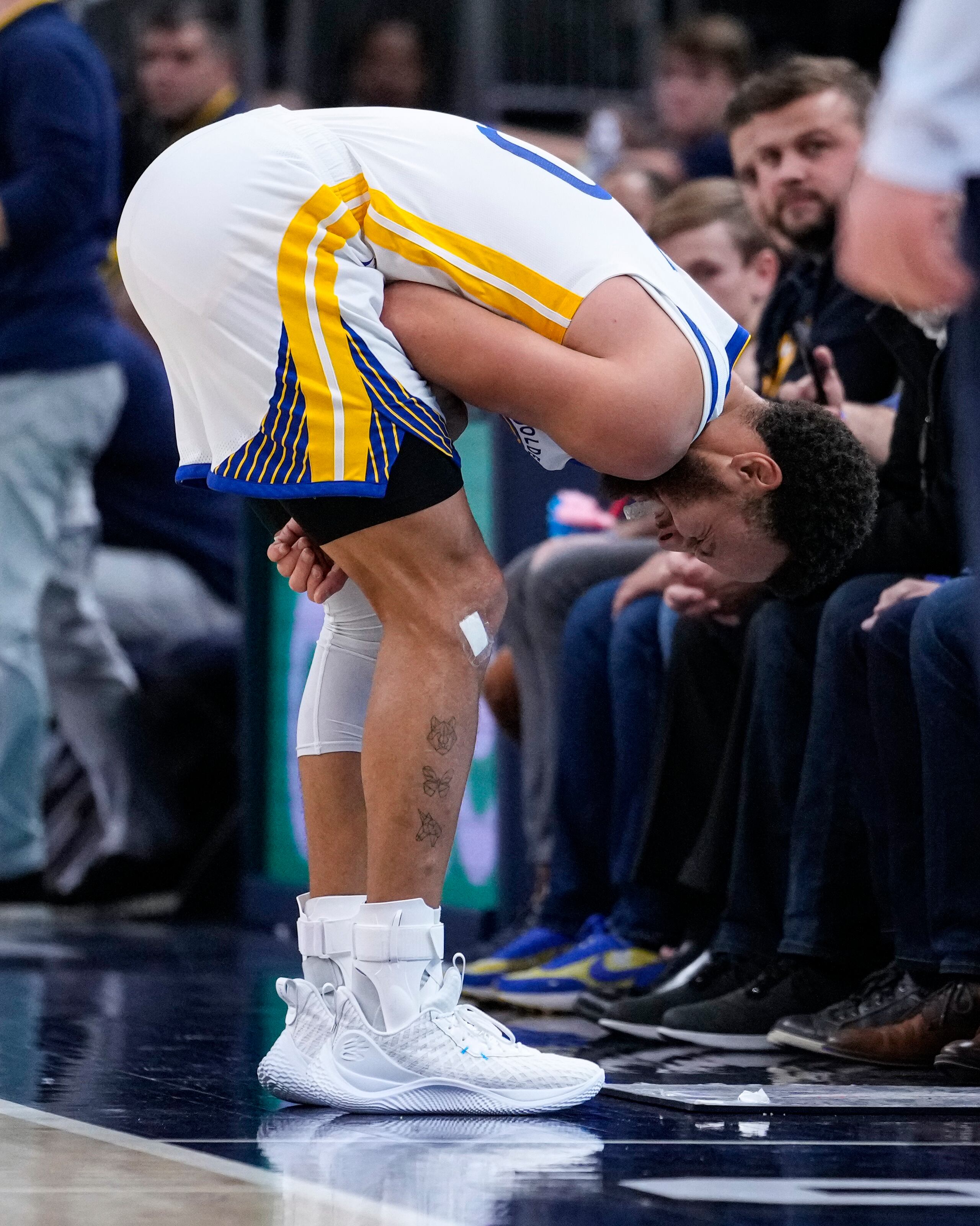 El defensa de los Warriors de Golden State, Stephen Curry, realiza un gesto de dolor luego de lastimarse un hombro durante el partido del miércoles ante los Pacers de Indiana.