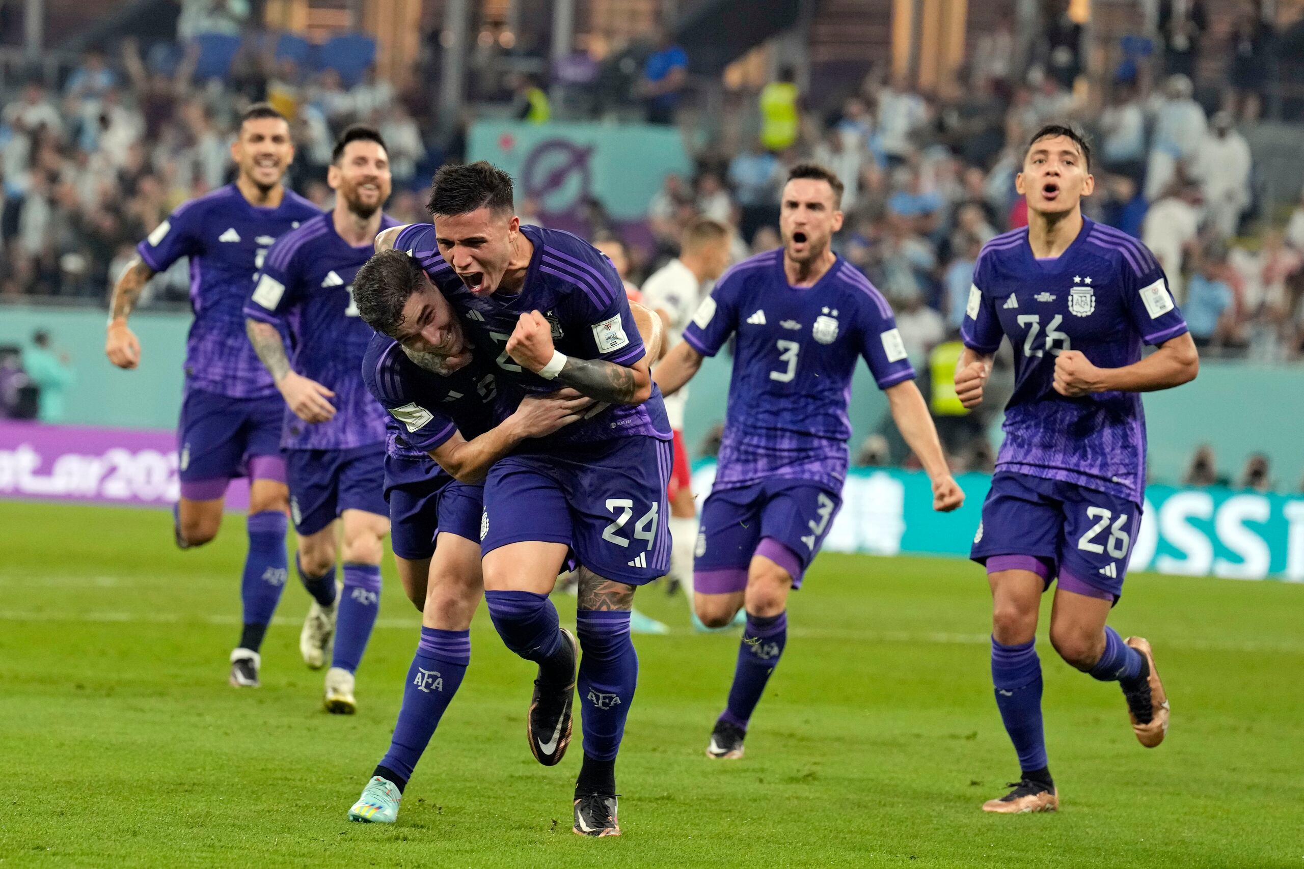 Julian Álvarez (izquierda, primer plano) recibe el saludo de su compañero Enzo Fernández tras anotar el primer gol de Argentina durante el partido contra Polonia por el Grupo C del Mundial, el miércoles 30 de noviembre de 2022. (AP Foto/Natacha Pisarenko)