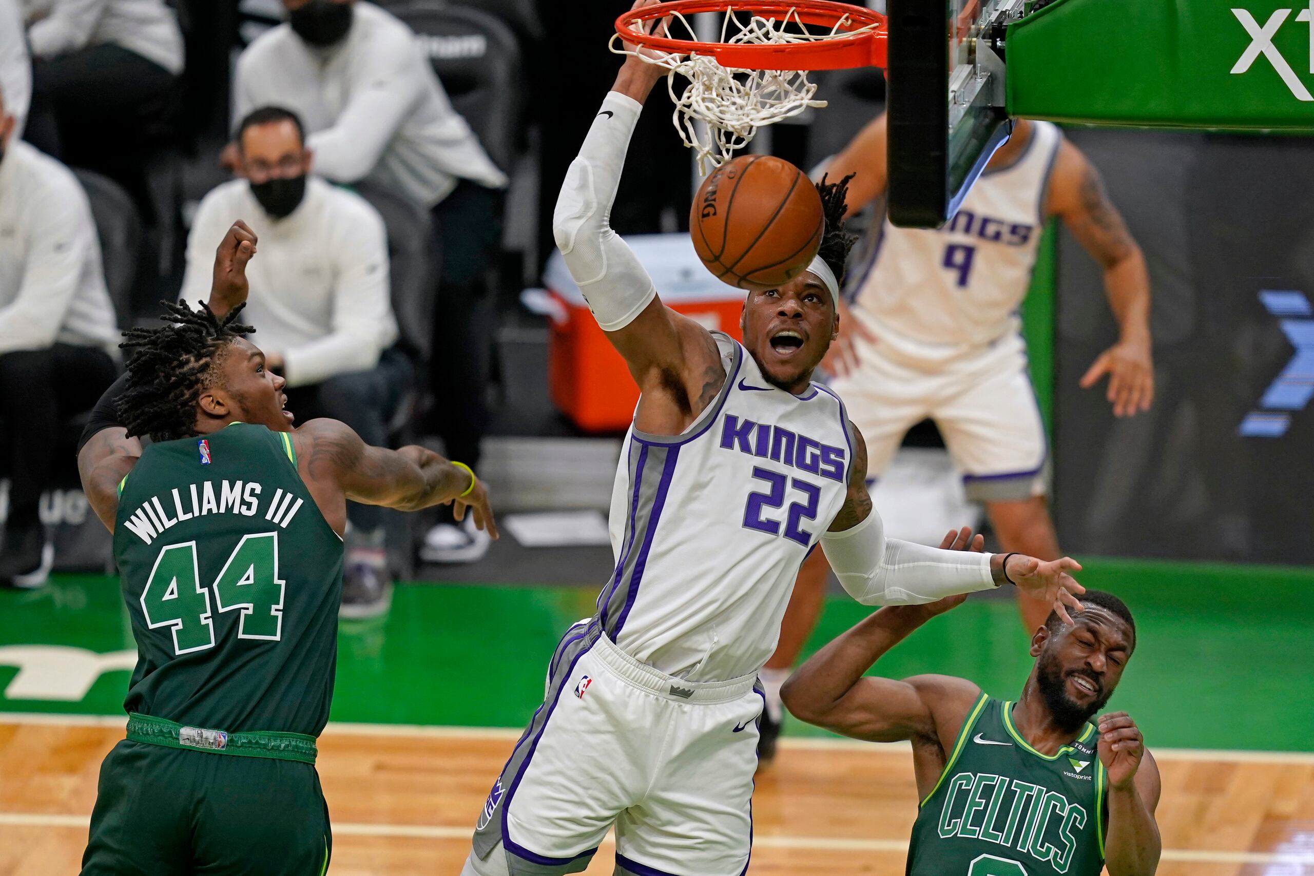 El pívot de los Kings de Sacramento, Richaun Holmes, anota sobre el pívot de los Celtics de Boston Robert Williams III y el base Kemba Walker durante el primer cuarto del partido.