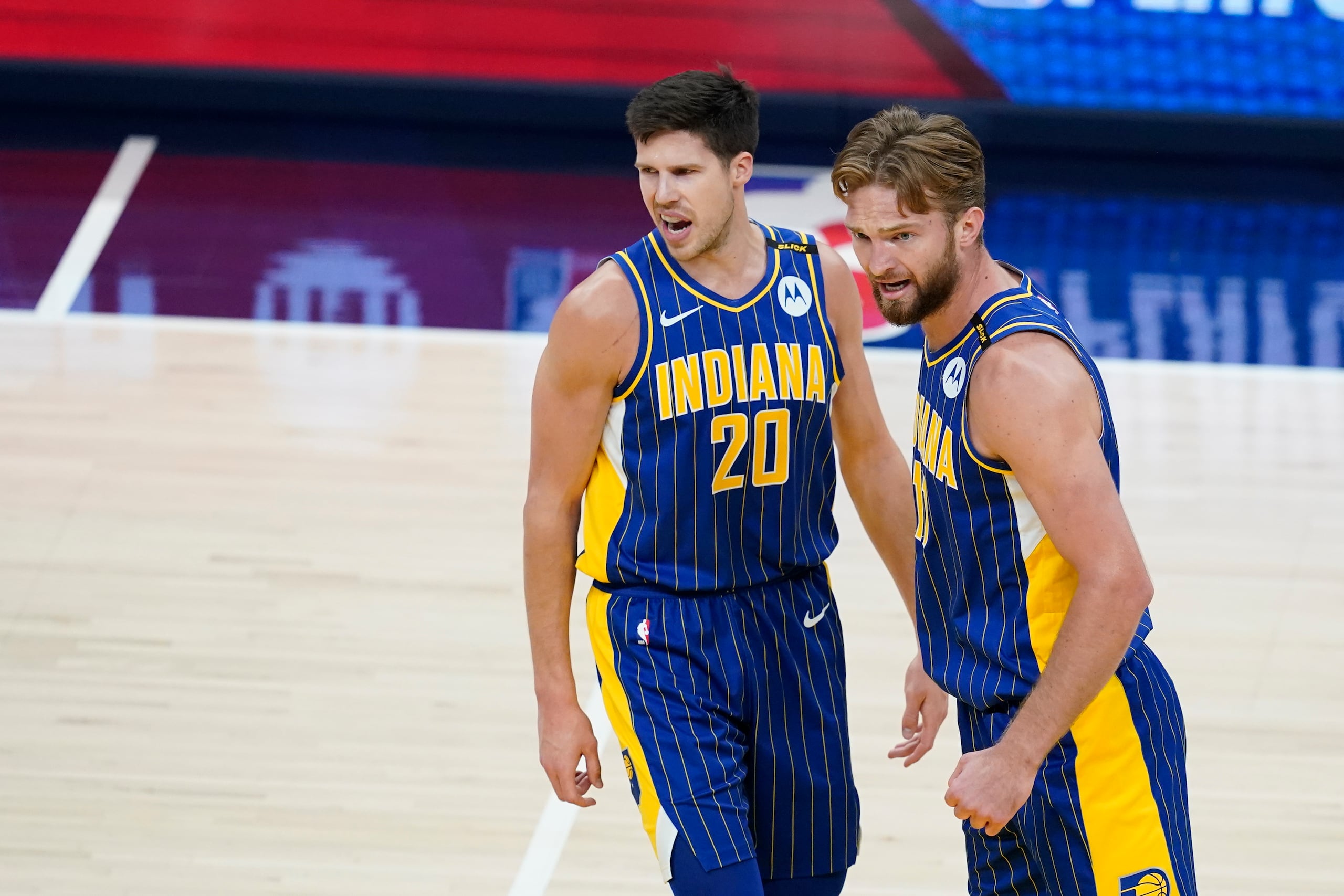 Doug McDermott (20) y Domantas Sabonis (11) reaccionan durante el partido "play-in" entre los Pacers y Hornets.