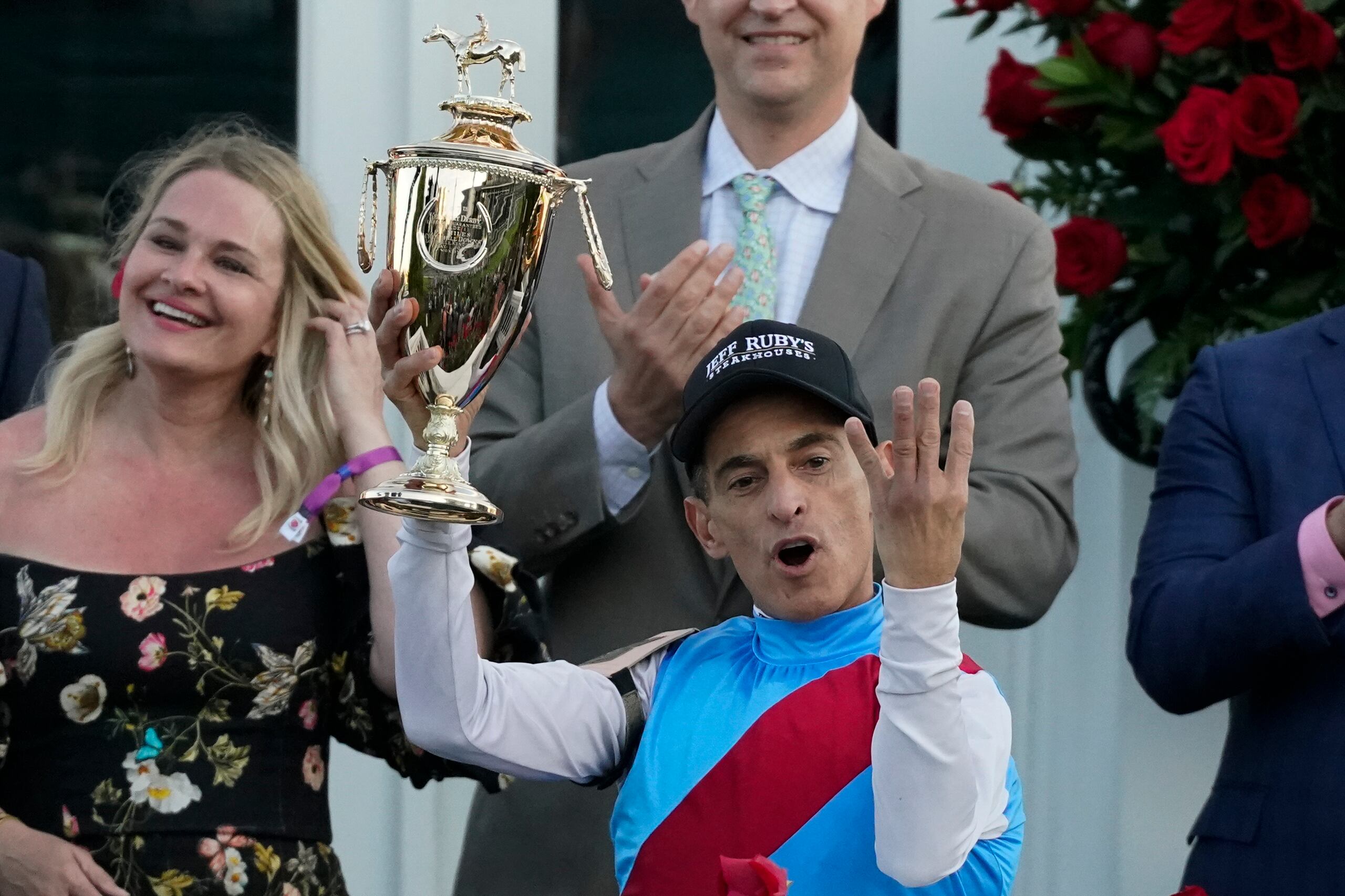 El jinete John Velázquez gesticula los cuatro triunfos que ha logrado en el Kentucky Derby luego de su victoria del sábado en esa carrera a bordo de Medina Spirit.