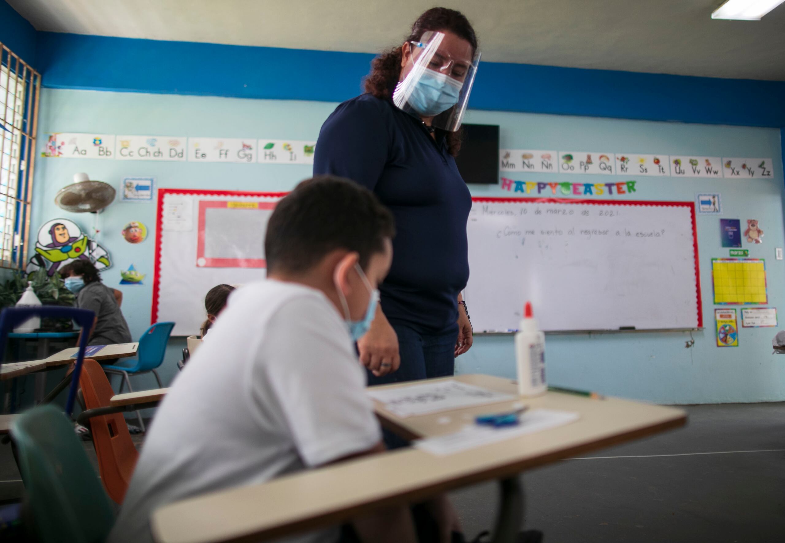 Hilda Nieves Márquez, maestra de segundo grado, atiende a uno de sus estudiantes.