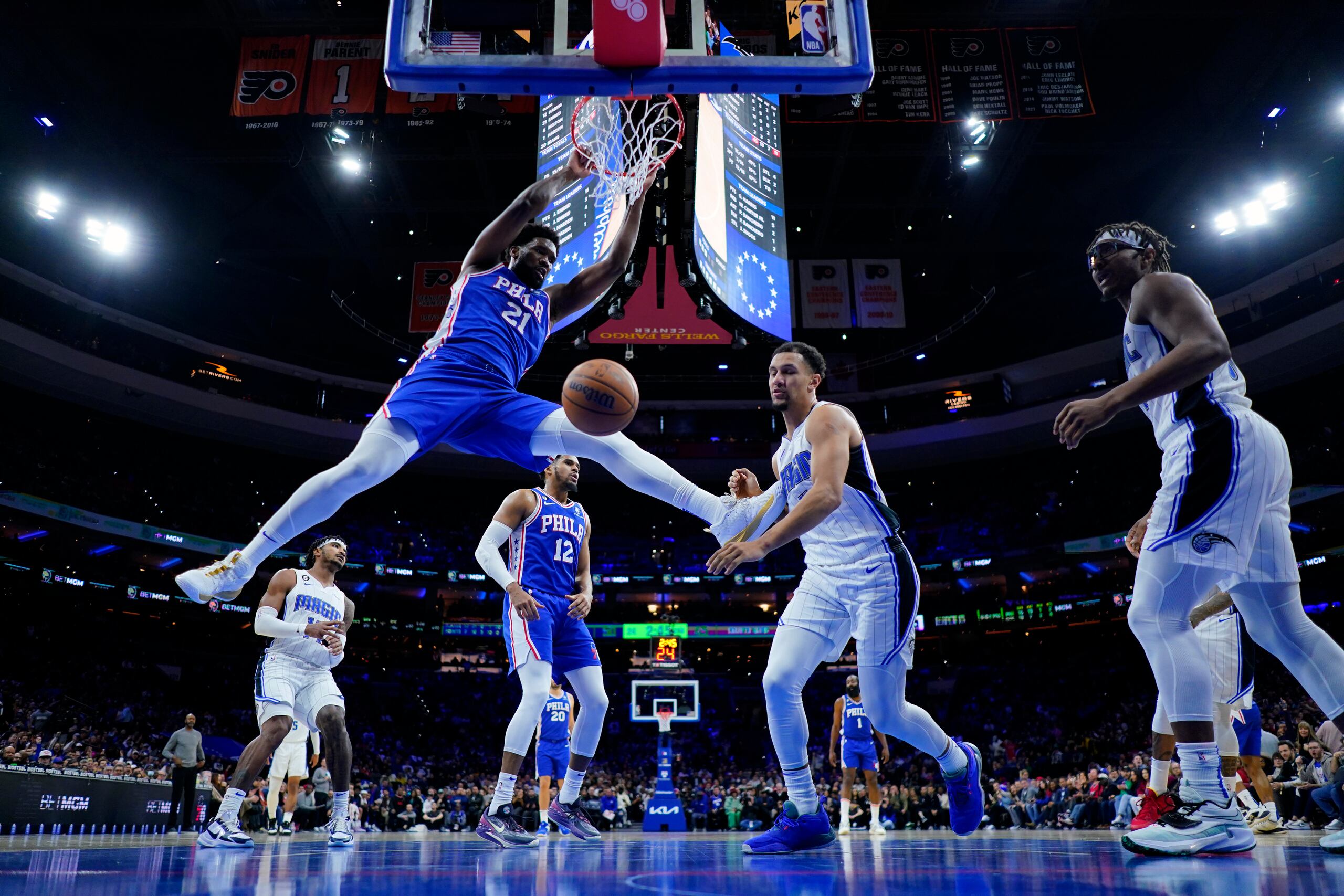 Joel Embiid (21), de los Sixers de Filadelfia, hunde el balón sobre Jalen Suggs (4), del Magic de Orlando, durante el encuentro del miércoles.