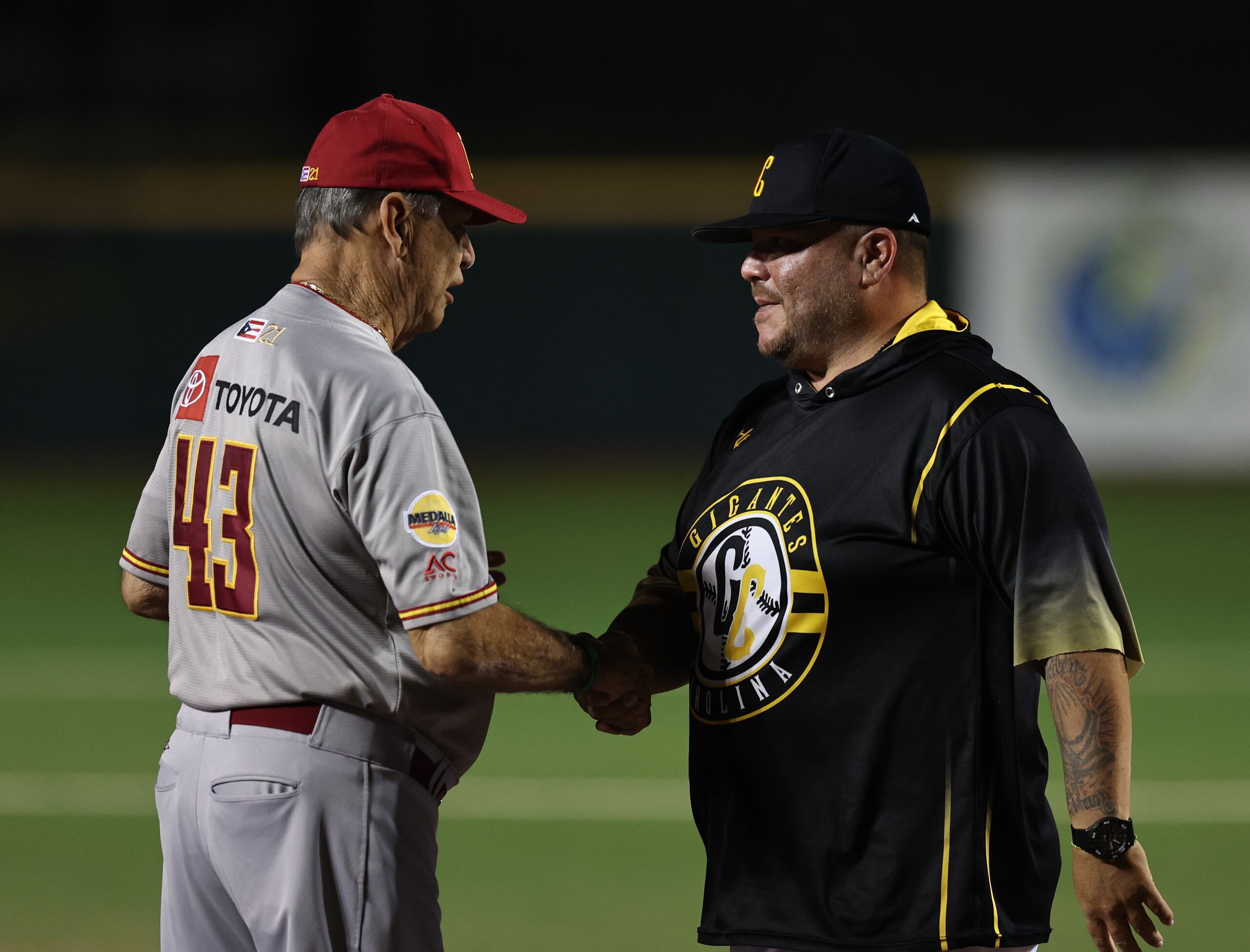 Mako Oliveras intercambia un saludo con Edwards Guzmán, quien fuera su jugador y es ahora el dirigente rival en la final entre los Indios y Gigantes.