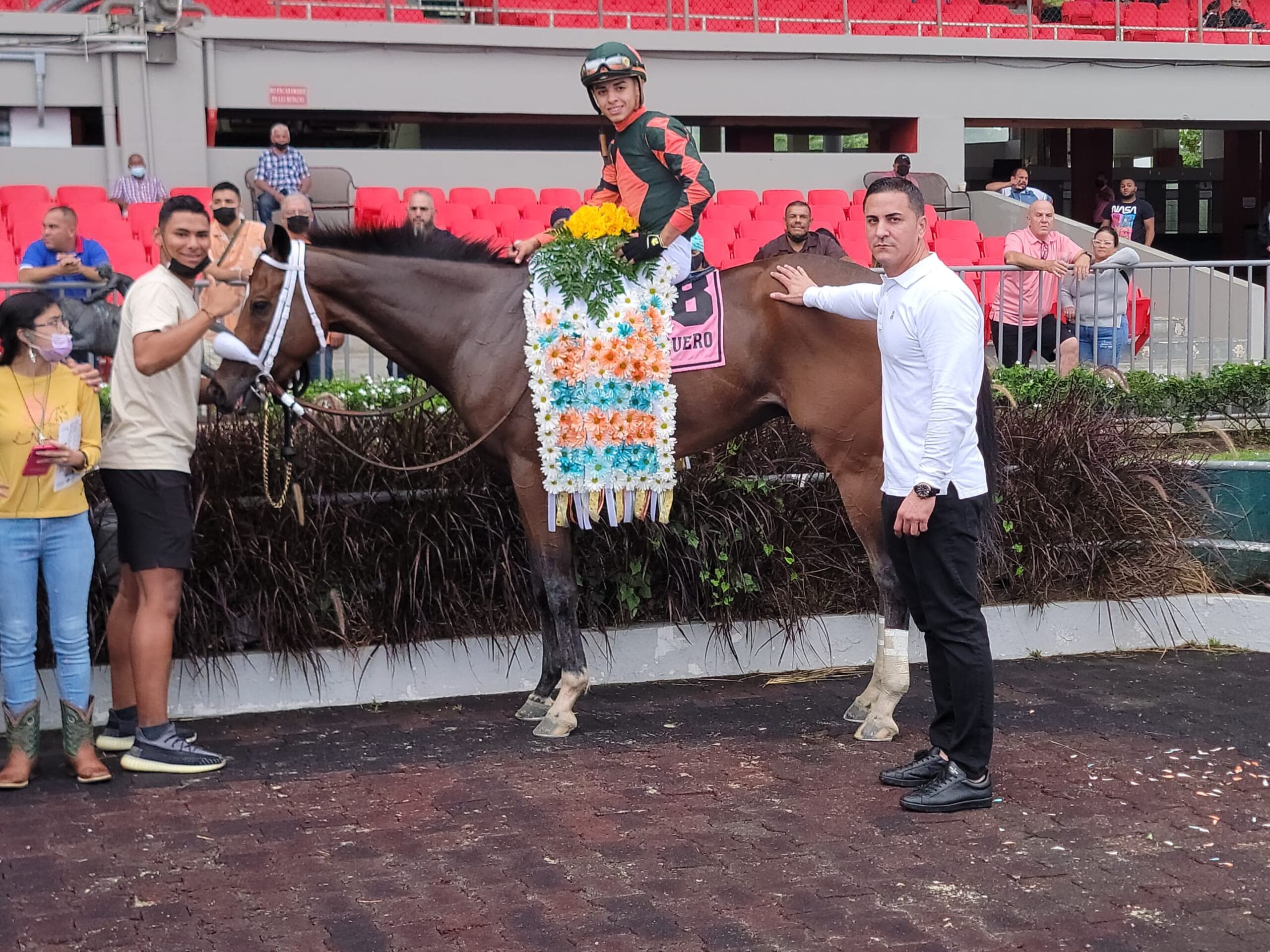 Banquero se retreta en el círculo de ganadores del Derbi Puertorriqueño junto a su jinete Jean Carlos Díaz y su entrenador José Dan Vélez (derecha).