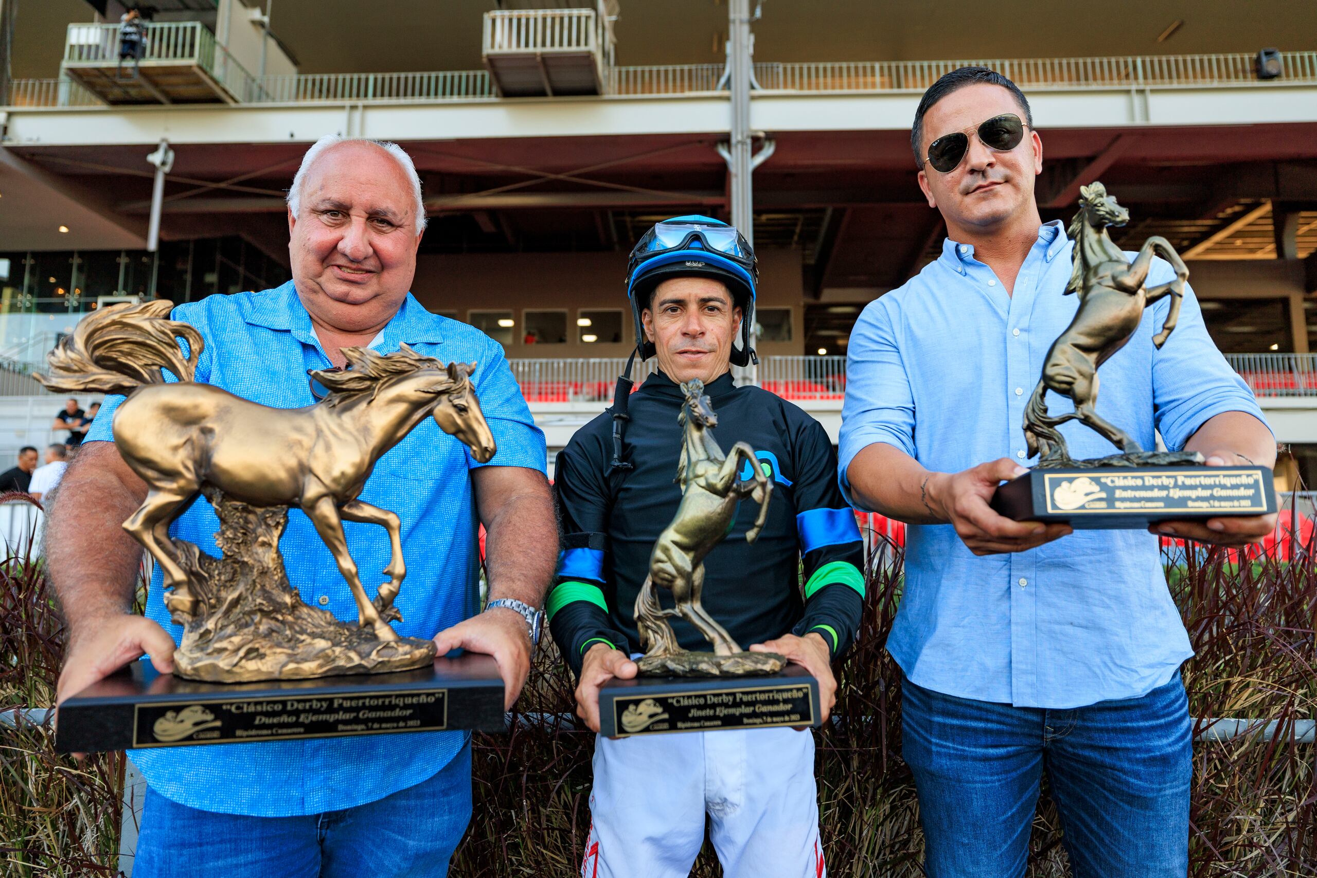 La conexión ganadora de Bastián: el dueño y criador Josean López, el jinete Juan Carlos Díaz y el entrenador José Dan Vélez posan de izquierda a derecha con el trofeo del Derby Puertorriqueño.