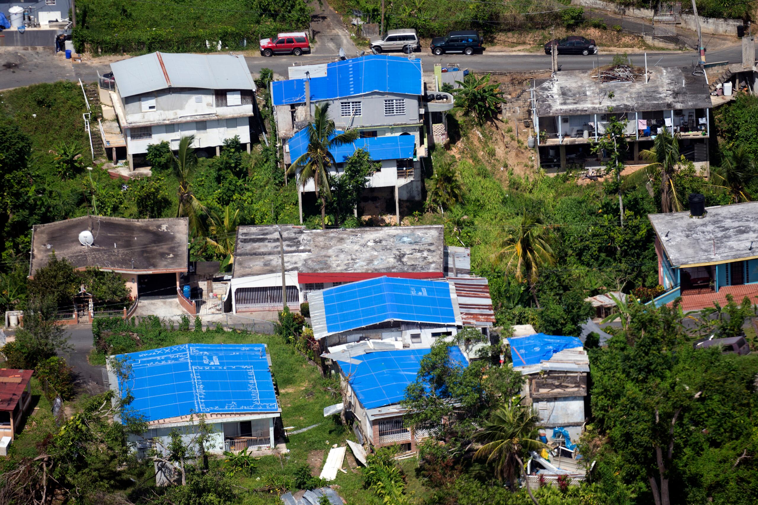 Imagen aérea de residencias con toldos azules.