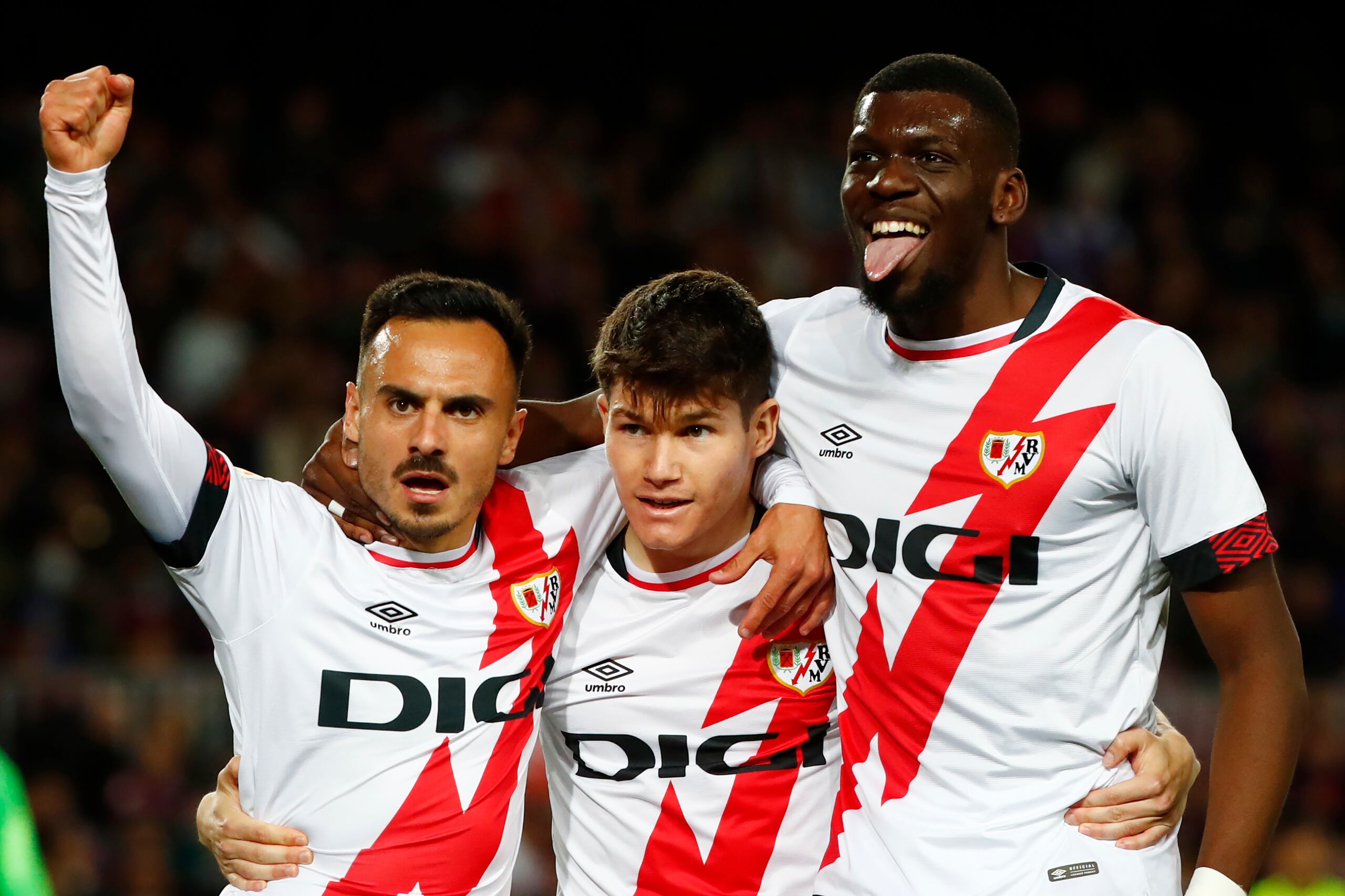 Fran García, centro, y Randy Nteka, derecha, festejan el gol de Álvaro García, izquierda, por el Rayo Vallecano en duelo de la Liga ante el Barcelona en el Camp Nou de Barcelona, España, el domingo 24 de abril de 2022. (AP Foto/Joan Monfort)