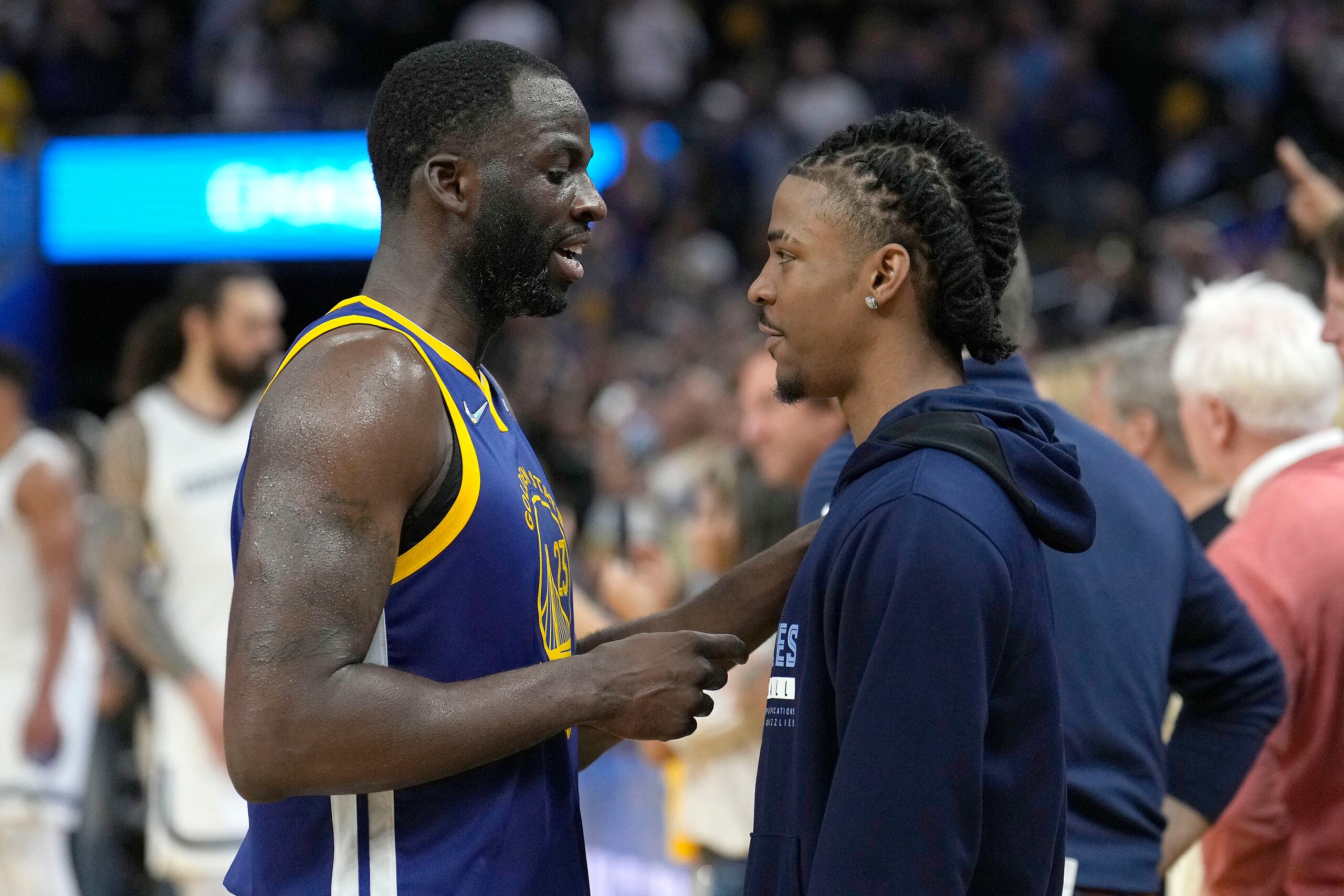 Draymond Green, de los Warriors de Golden State, conversa con la estrella de los Grizzlies de Memphis, Ja Morant.