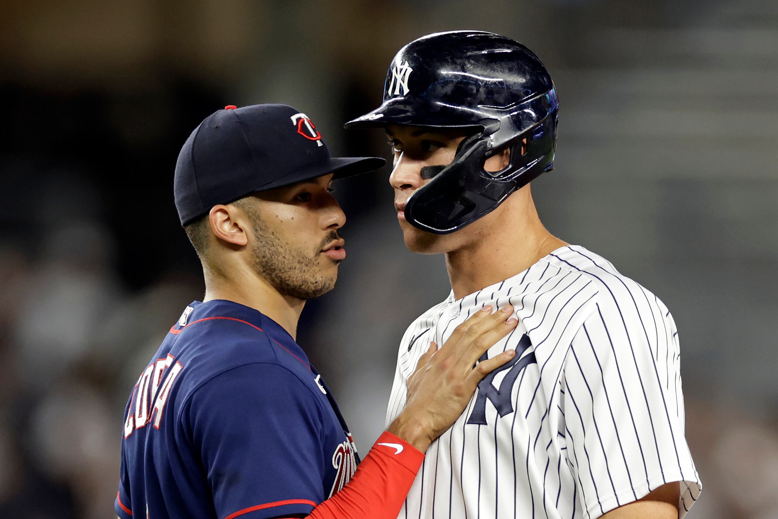 El infielder boricua de los Twins de Minnesota, Carlos Correa, a la izquierda, habla con Aaron Judge, de los Yankees de Nueva York, durante un partido entre los Yankees y Twins en la recién concluida temporada.