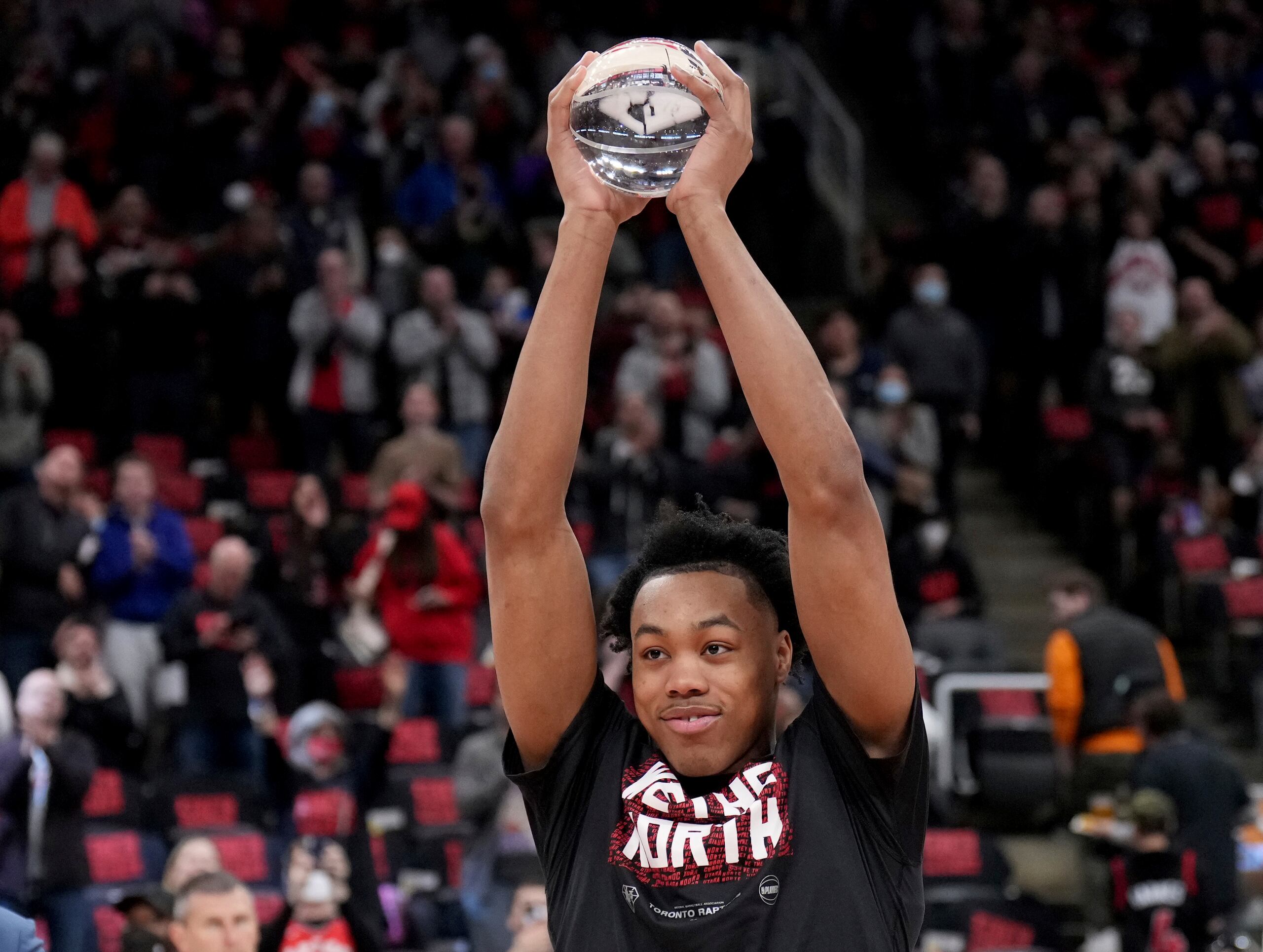 El Novato del Año de la NBA, Scottie Barnes, de los Raptors de Toronto Raptors, levanta el galardón que le fue entregado el sábado antes del partido de su equipo ante los Sixers de Filadelfia.