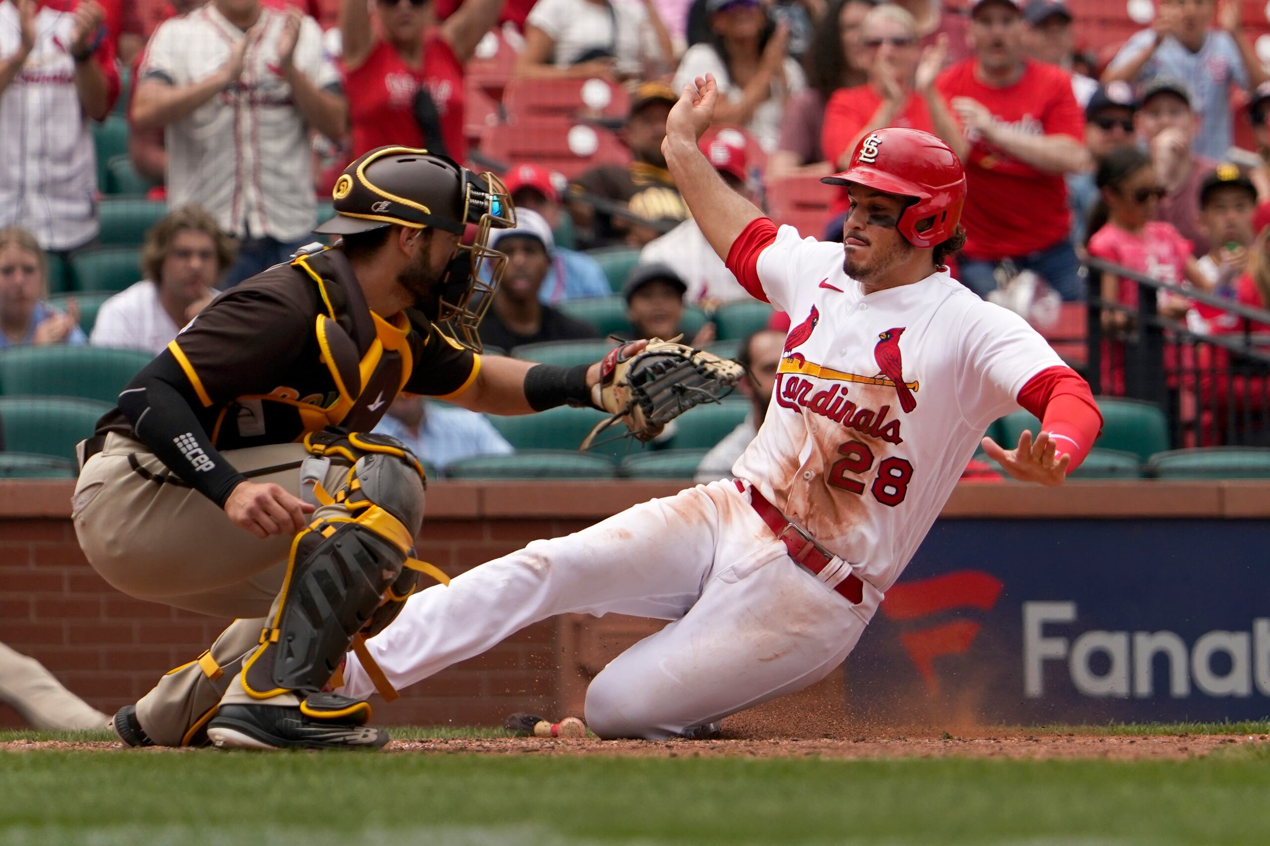 El toletero de los Cardenales de San Luis Nolan Arenado (28) se desliza en el plato evadiendo al catcher de San Diego Austin Nola en el octavo inning de un partido de las Grandes Ligas el 1 de junio del 2022.  (AP Foto/Jeff Roberson)