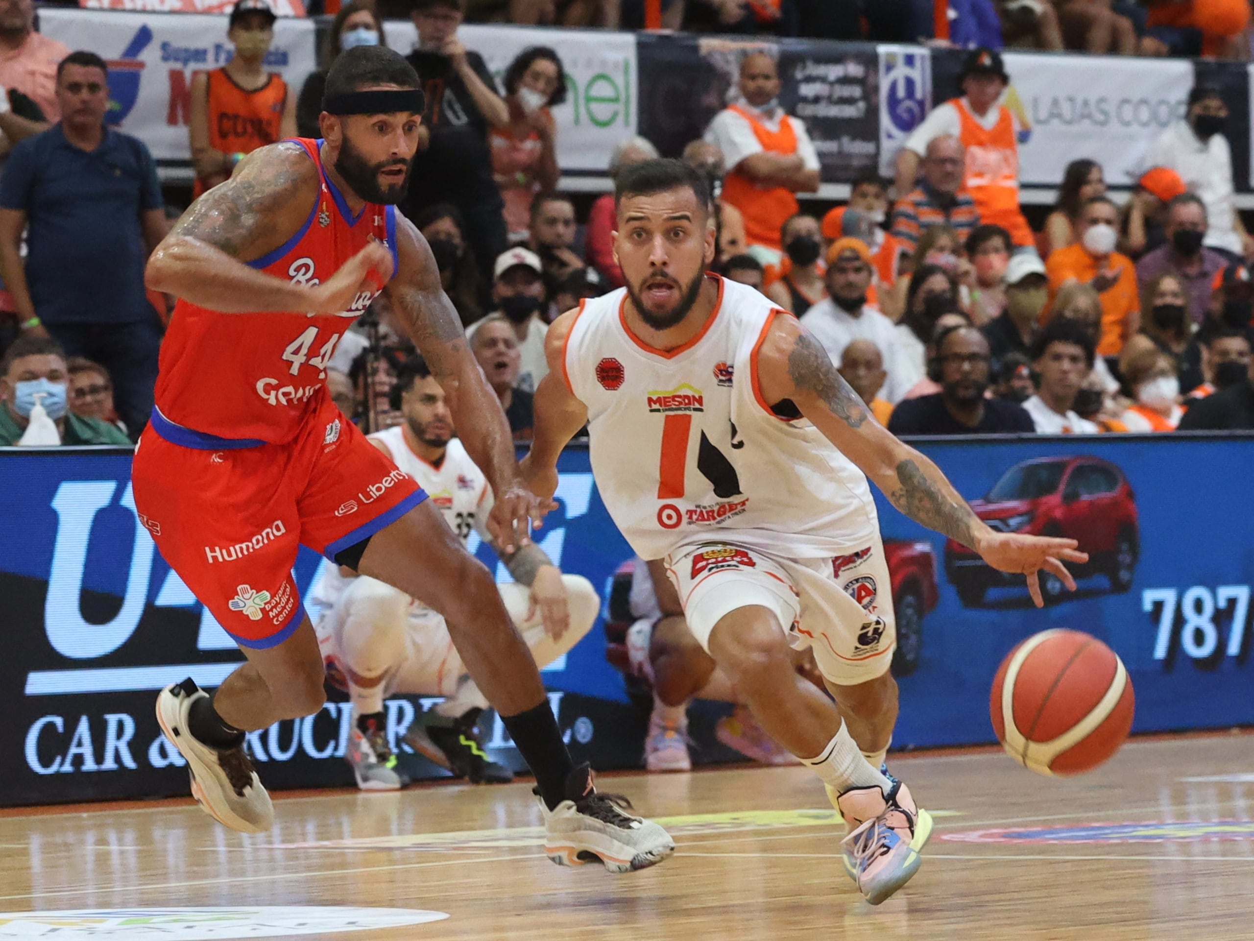 Tjader Fernández, con el balón por los Atléticos de San Germán, y  Javier Mojica, en la defensa de los Vaqueros de Bayamón, jugaron duro en la serie final del BSN.